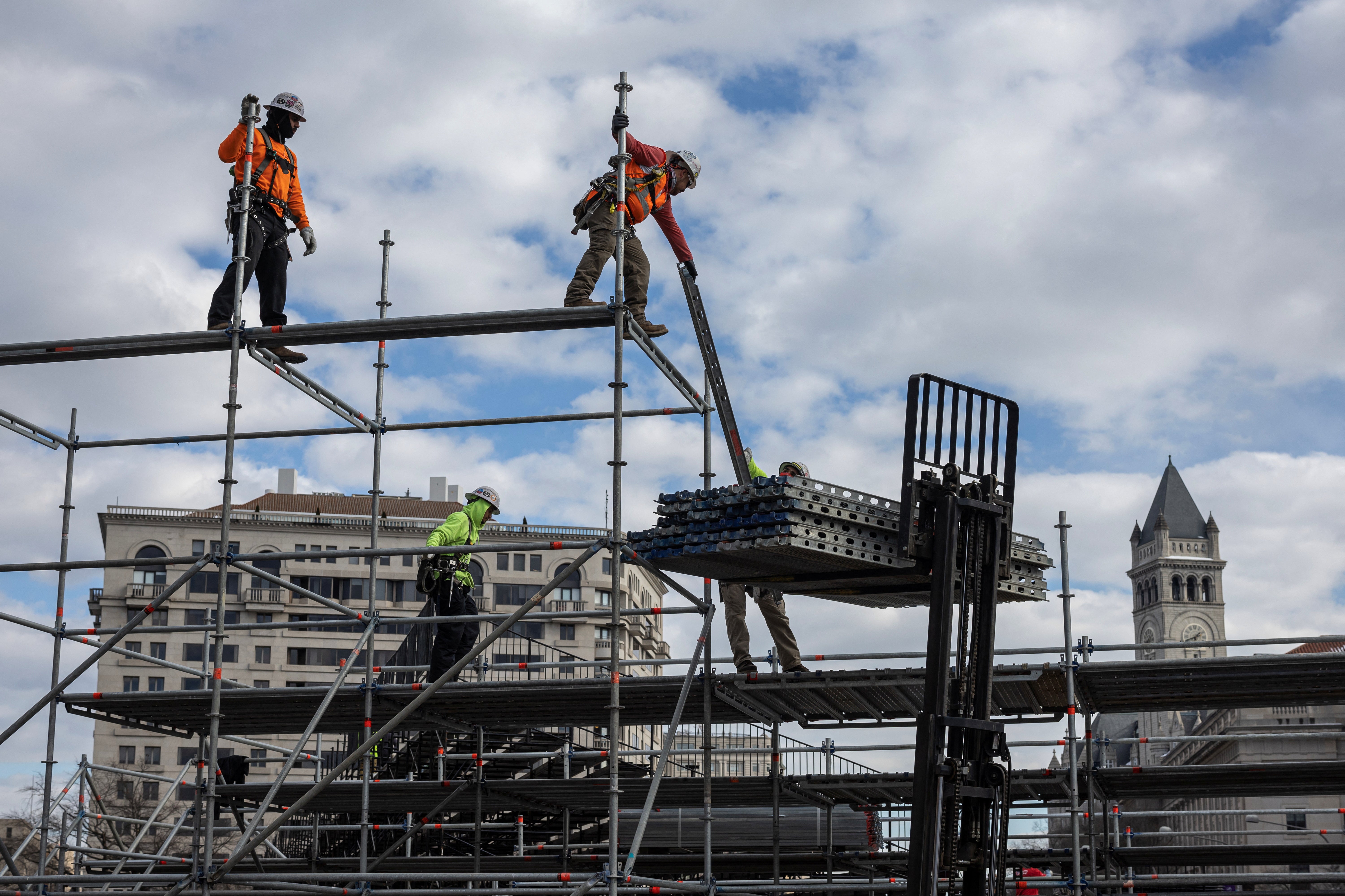 Construction workers finish up the reviewing stand on Pennsylvania Avenue. Nearly half a million —$449,736 — has been wagered on the number of executive orders Trump will issue on his first day in office