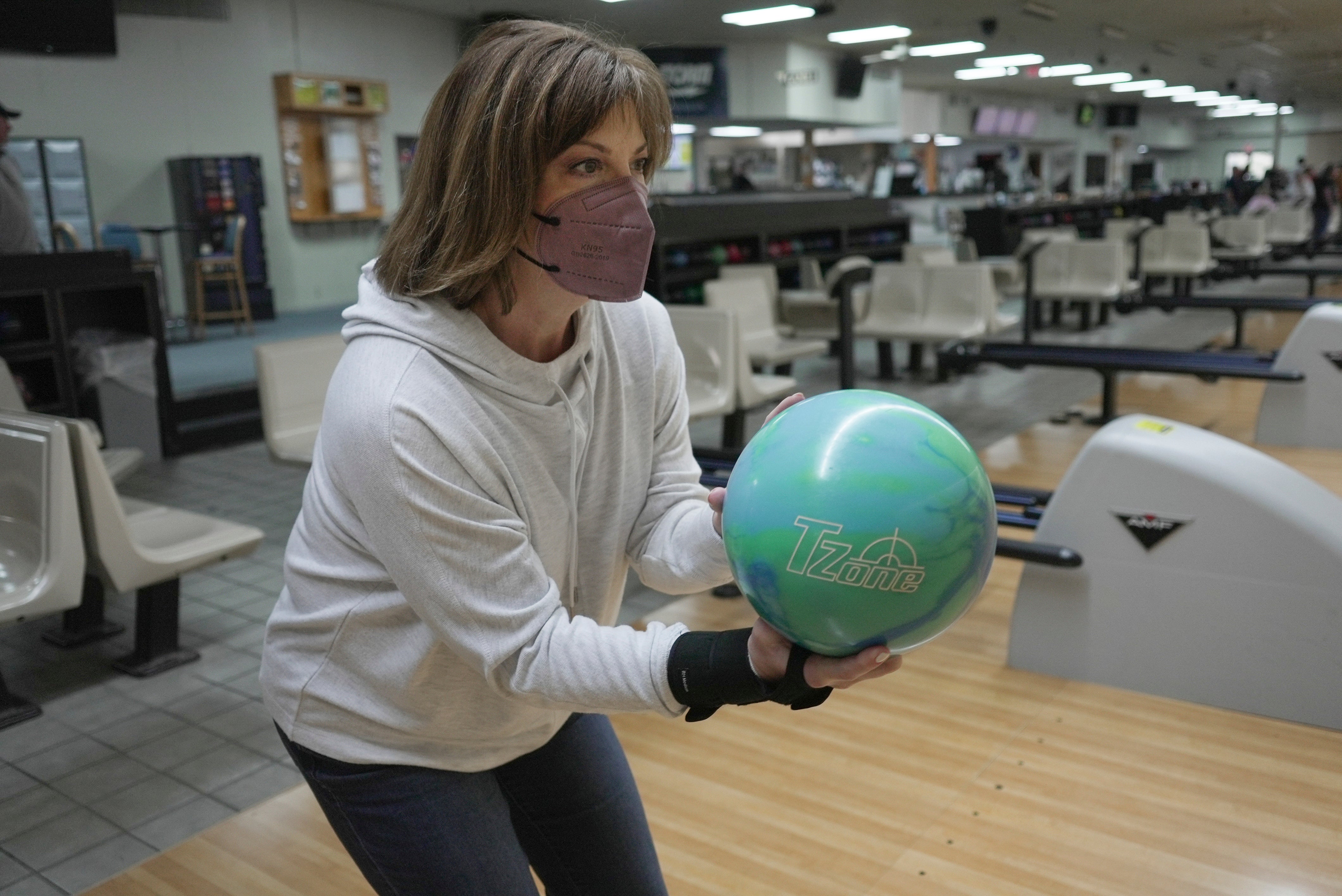 Susan Scarbro bowls while wearing a mask in Little River, S.C. on Jan. 3, 2025. (AP Photo/Laura Bargfeld)