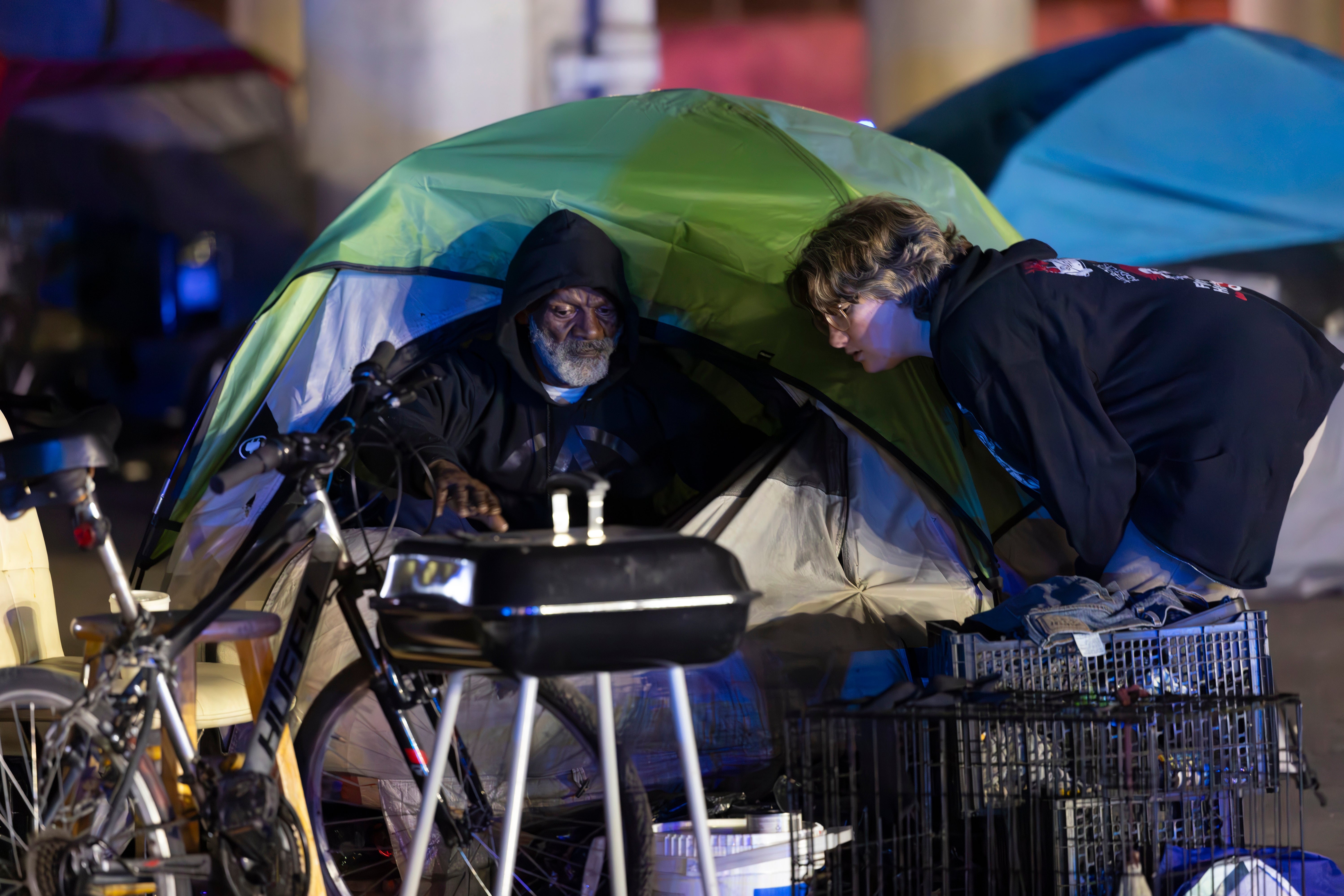 Homeless advocates assist people living in tents at a homeless encampment in New Orleans