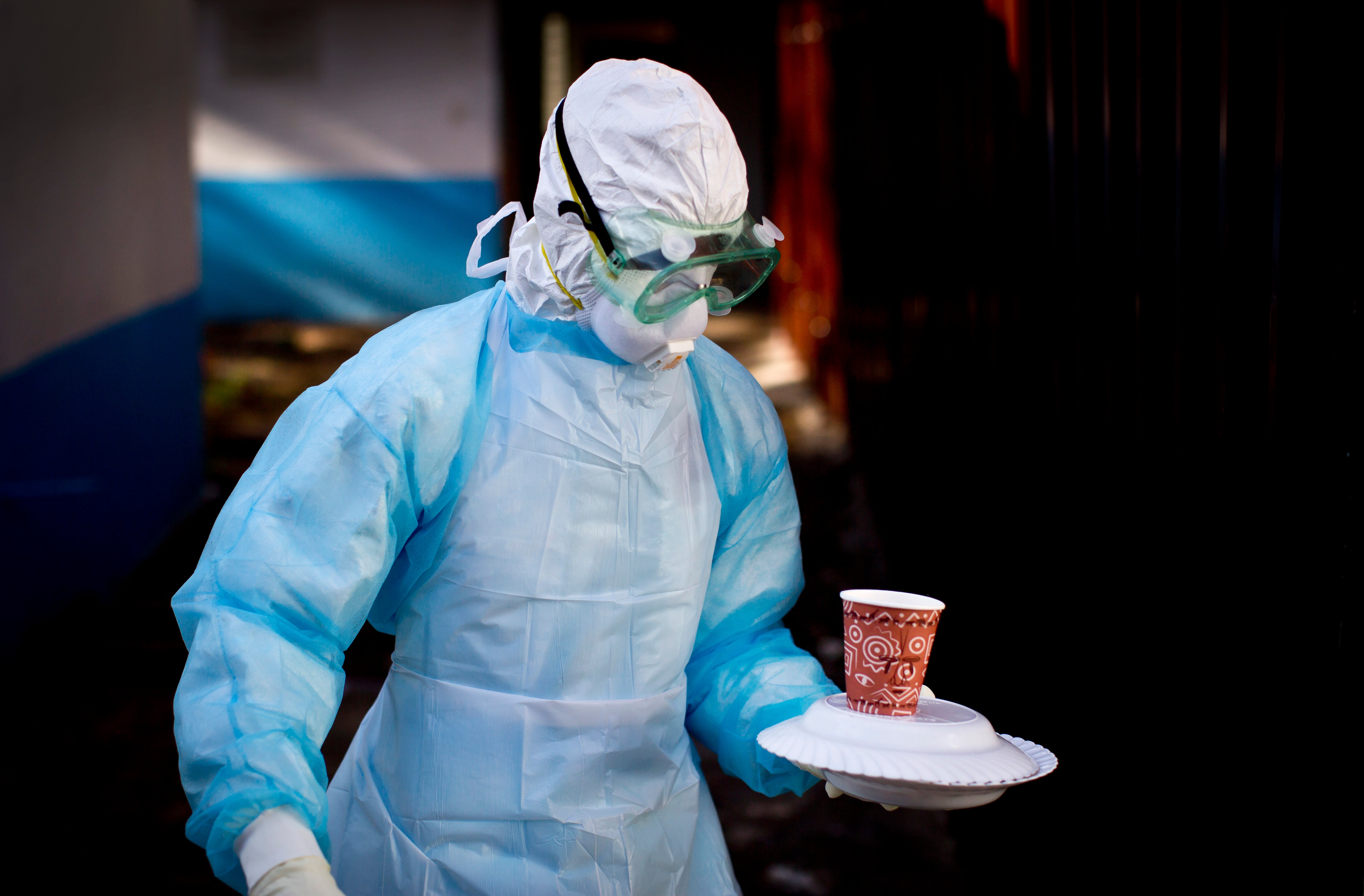 File. A medical worker carries a meal to an isolation tent housing a man being quarantined after coming into contact in Uganda with a carrier of the Marburg virus