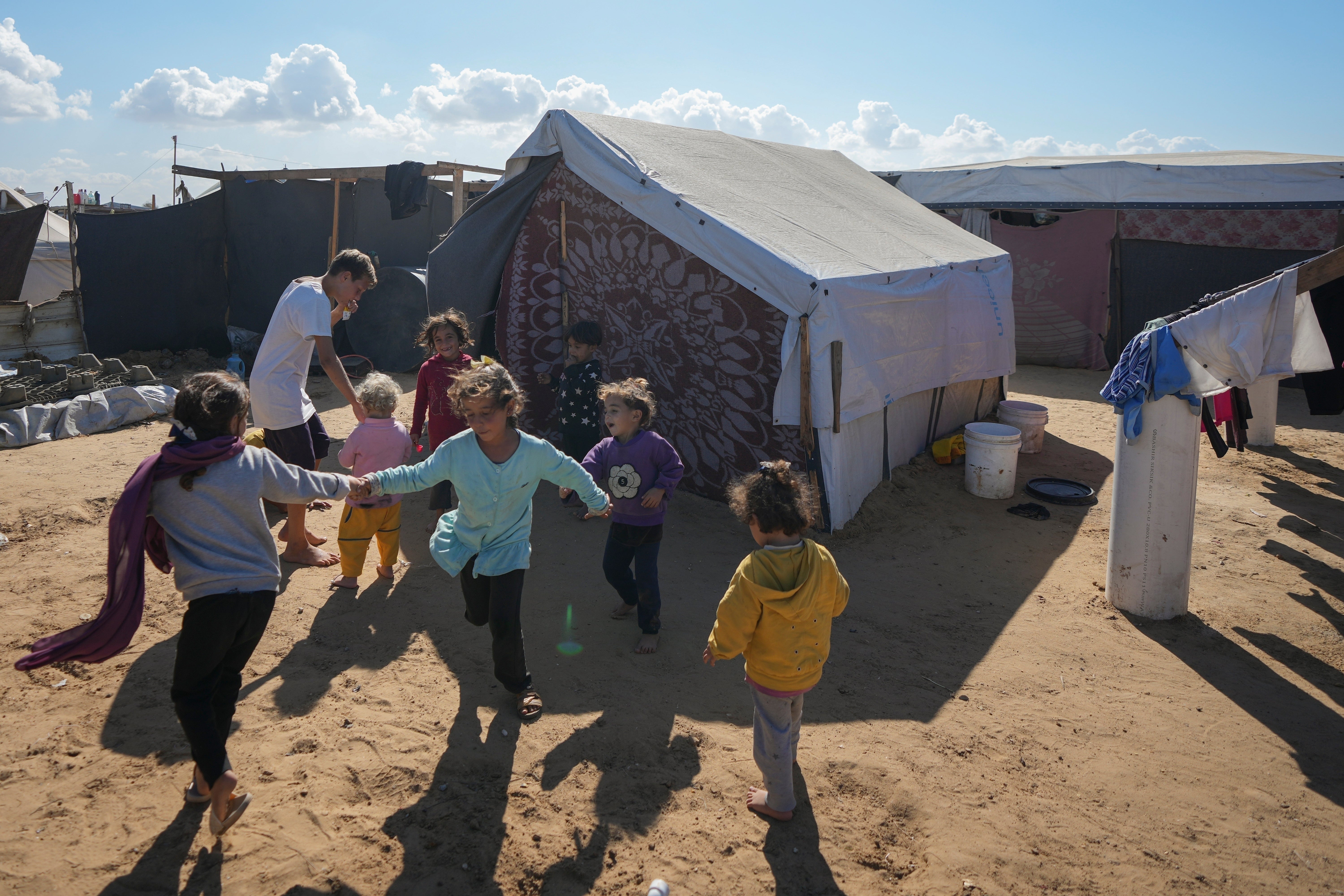 Children play next to their tent in a refugee camp in Deir al-Balah, Gaza Strip, on 19 November 2024