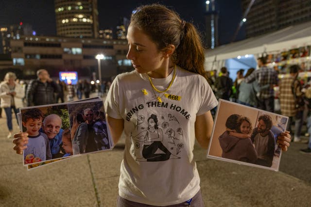 <p>Shay Dickmann stands holding the image of her captured cousin (right) who will never make it home and the elderly male hostages who remain in Gaza and could be freed in the new deal </p>