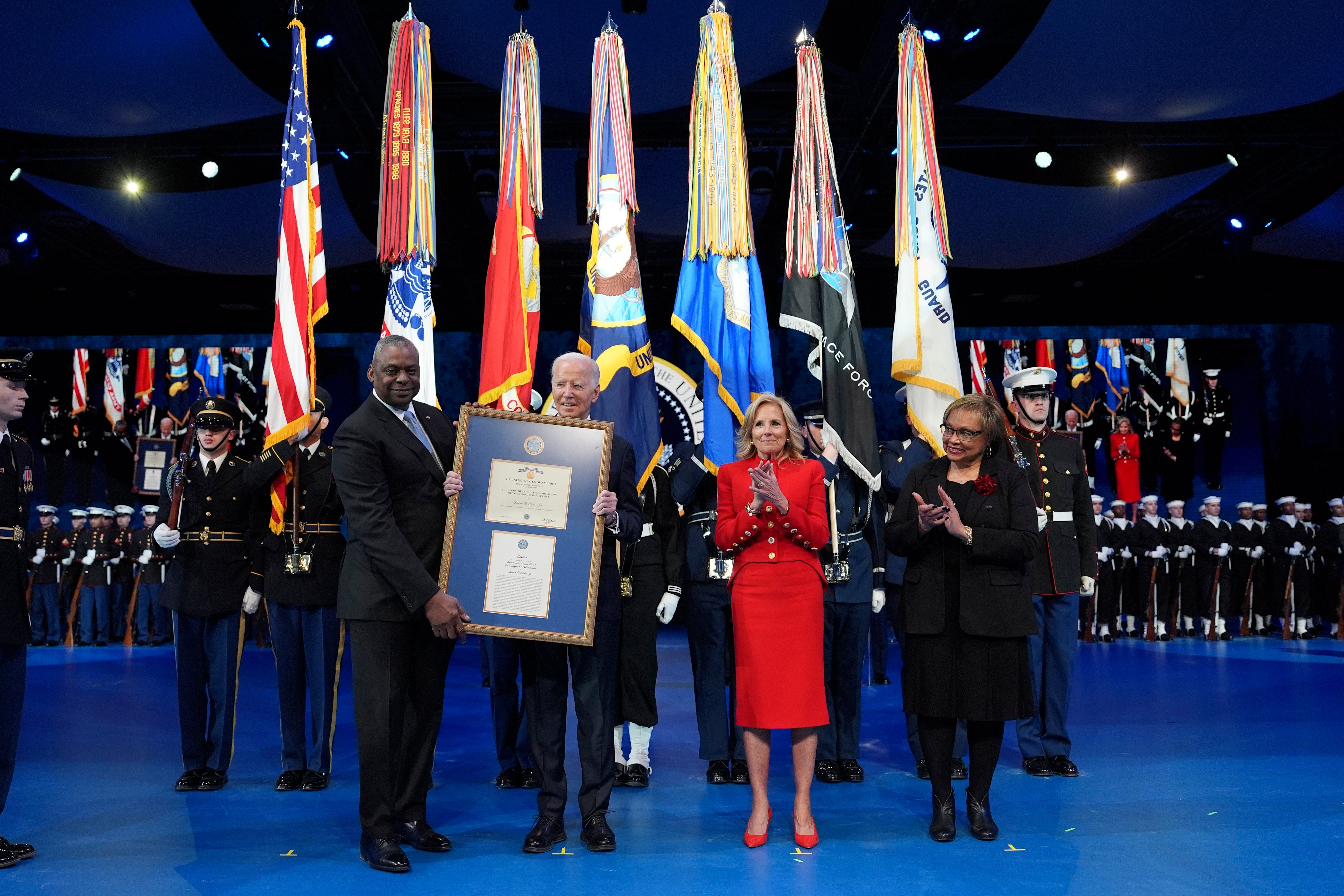 Defense Secretary Lloyd Austin, from left, presents a plaque to President Joe Biden for the medal for Distinguished Public Service as First Lady Jill Biden and Charlene Austin watch during a Department of Defense Commander-in-Chief farewell ceremony at Joint Base Myer-Henderson Hall