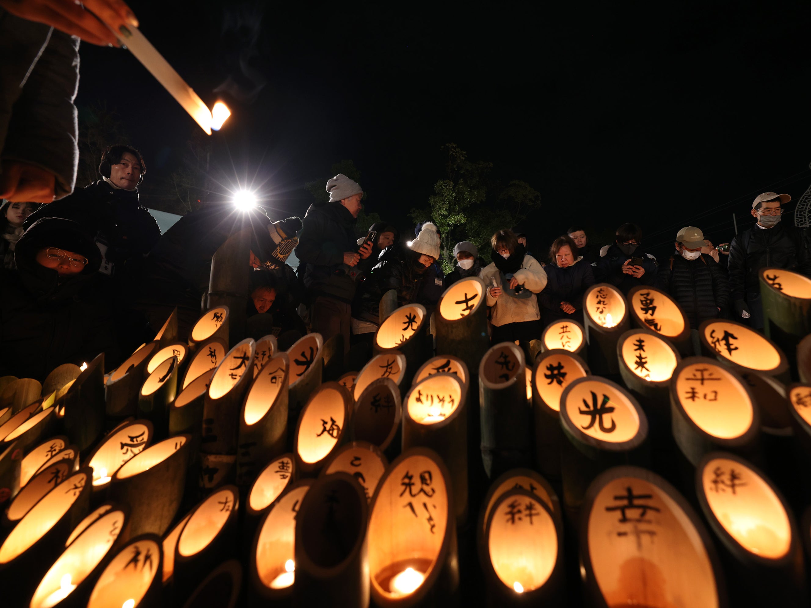 People light bamboo candles at a memorial altar for the victims of the Great Hanshin Earthquake during a memorial ceremony on 17 January 2025 in Kobe, Japan. People gathered early in the morning to pay their respects and light bamboo lanterns in the park for more 6,000 people who lost their lives in the 7.3 magnitude Hanshin Earthquake