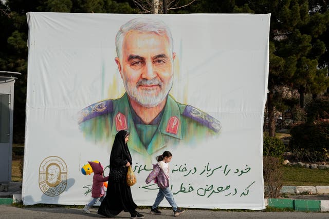 <p>File. A family walks past a portrait of Iranian general Qassem Soleimani, who was assassinated by the US in 2020, after the Friday prayers in Tehran on 17 January 2025</p>