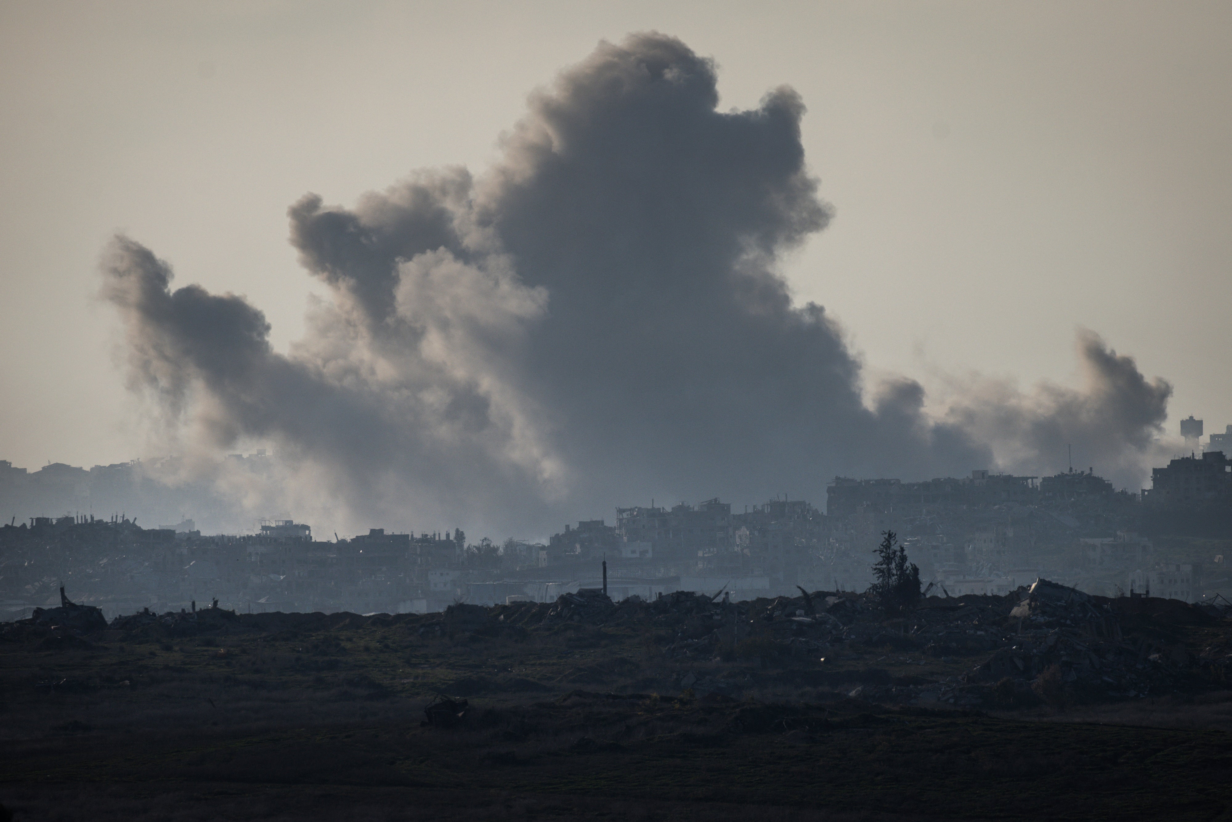 Smoke plumes rise from explosions above destroyed buildings in the northern Gaza Strip on Saturday