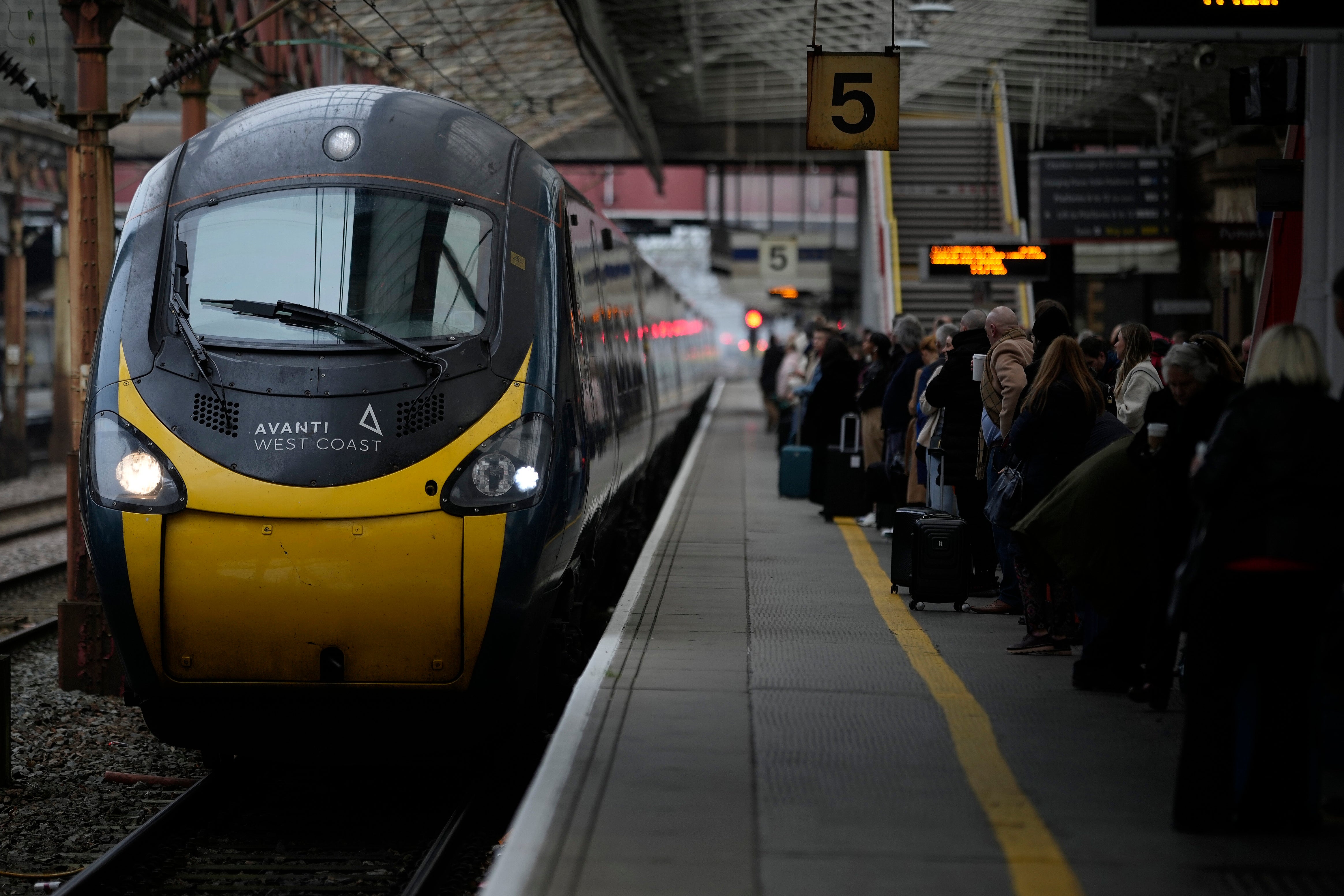 Passengers wait to board an Avanti West Coast mainline train at Crewe Station in Crewe