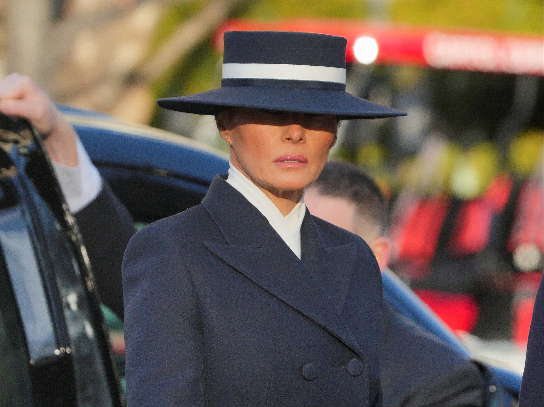Melania was dressed in a tailored navy blue coat and a wide-brimmed hat