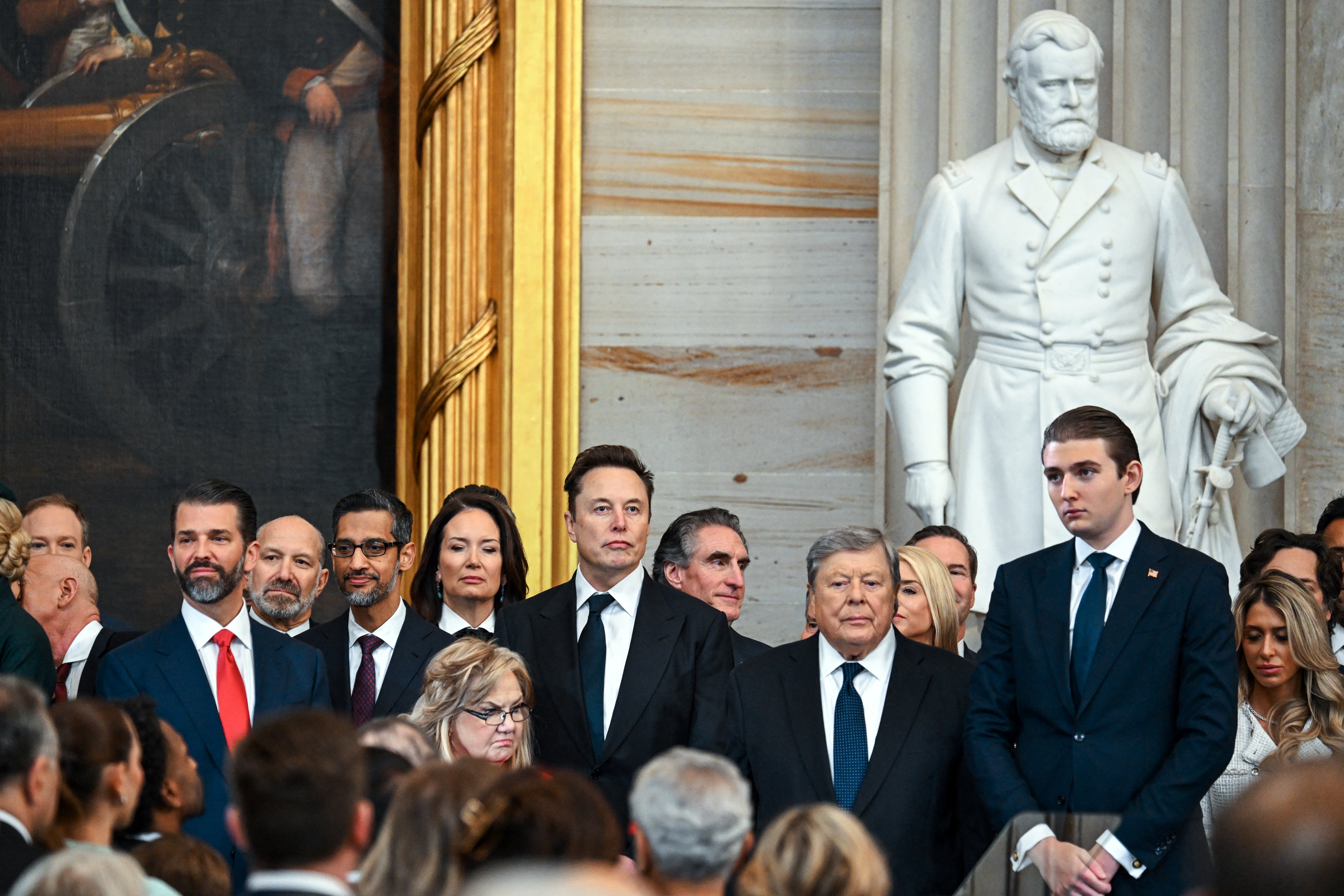 Musk stands near Barron Trump and Don Trump Jr during the inauguration