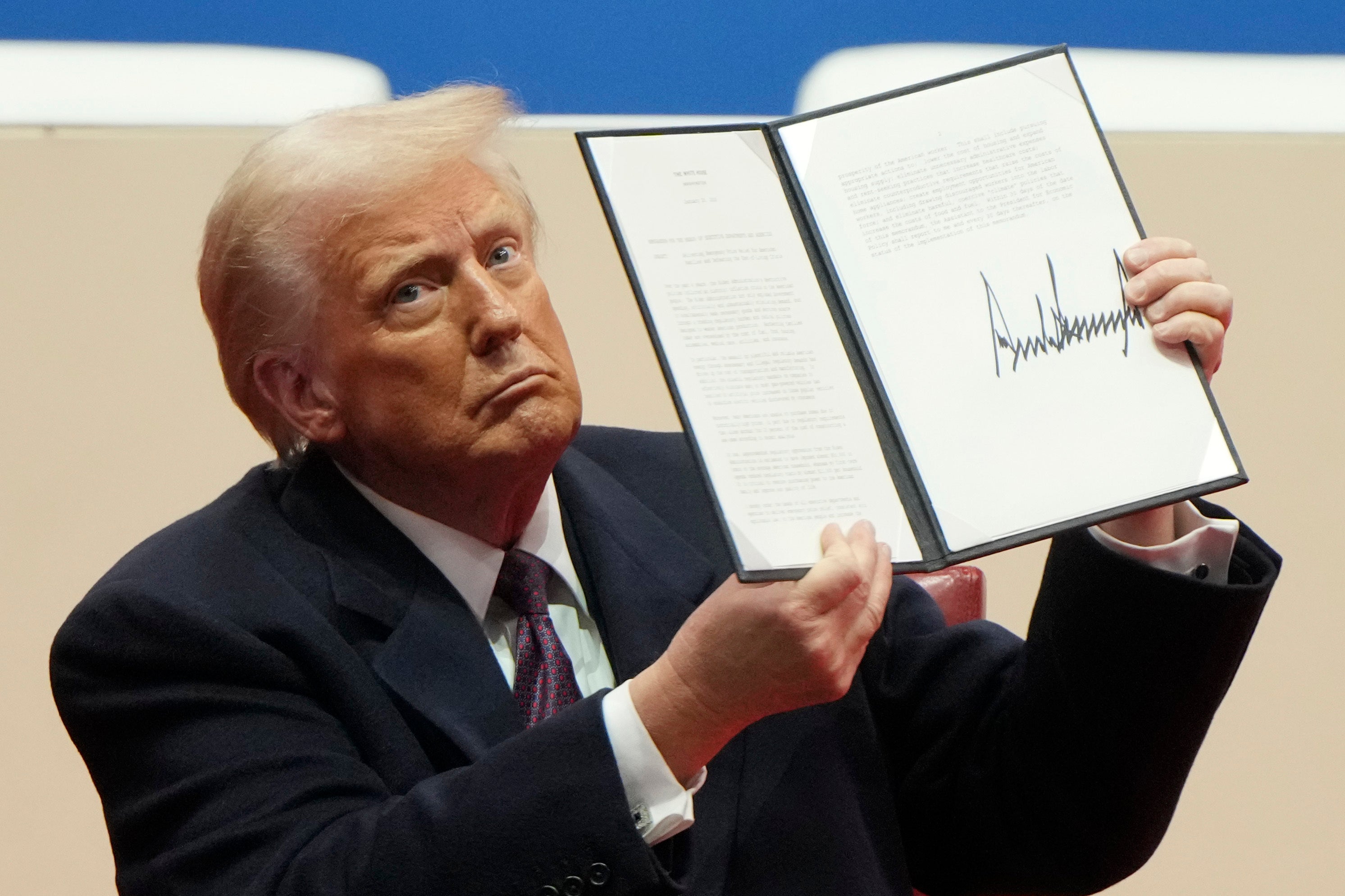 Donald Trump holds up one of his many executive orders Monday
