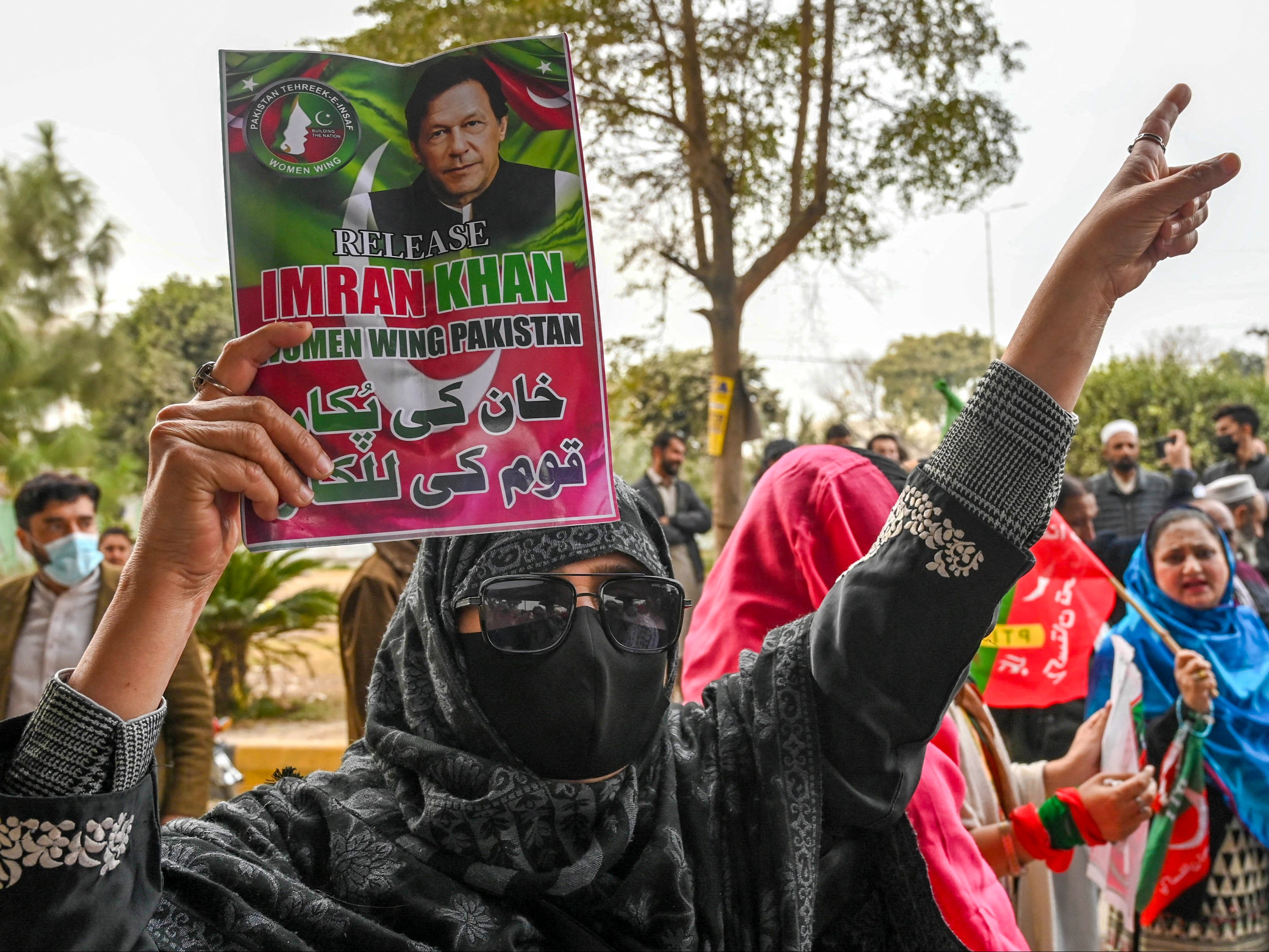 File. Pakistan’s imprisoned former prime minister Imran Khan’s supporters hold Khan’s portrait during a protest in Peshawar earlier this year