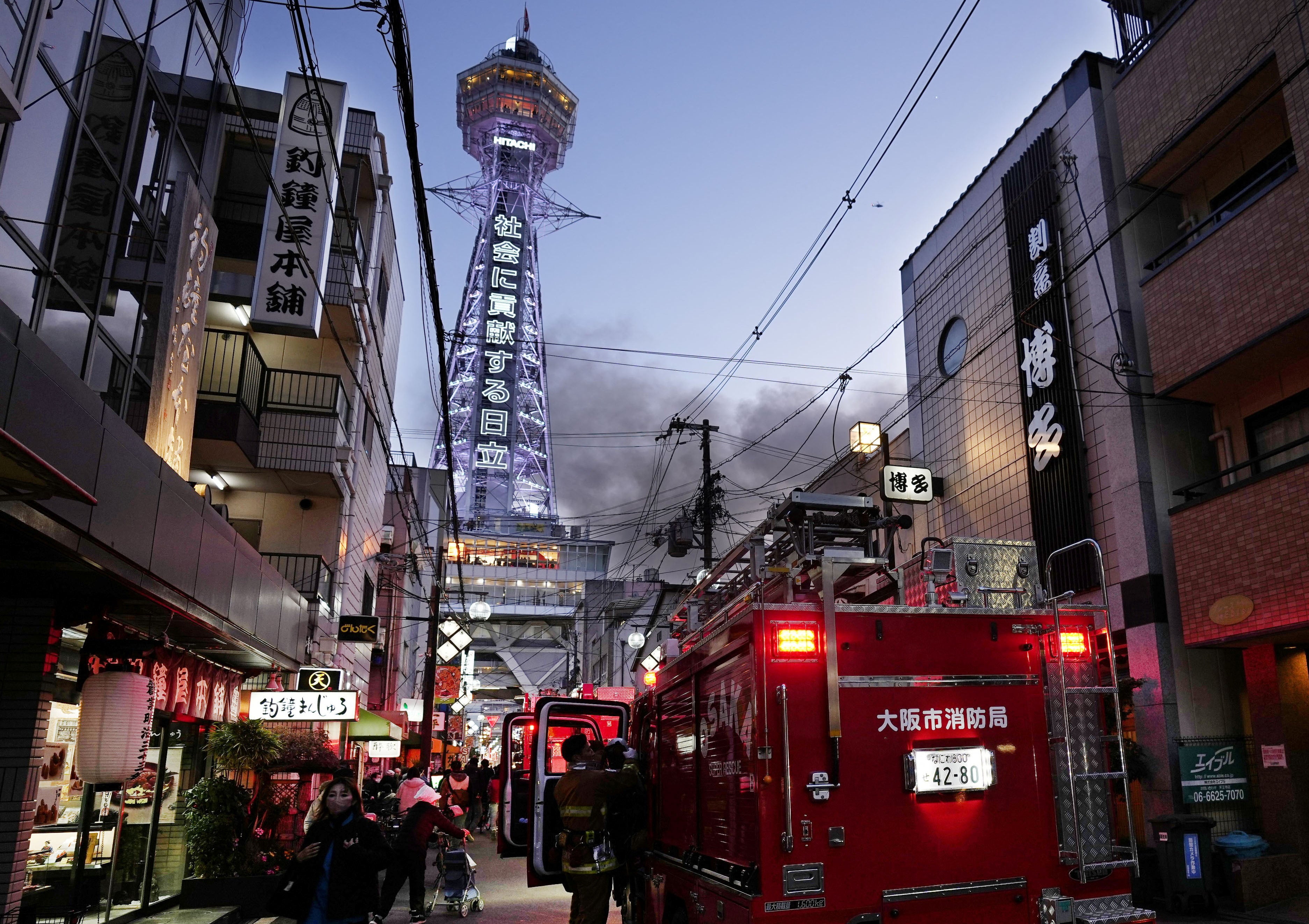 Smoke rises from a fire site at a commercial building near a famous tourist landmark Tsutenkaku Tower, in Osaka, Japan, 21 January 2025