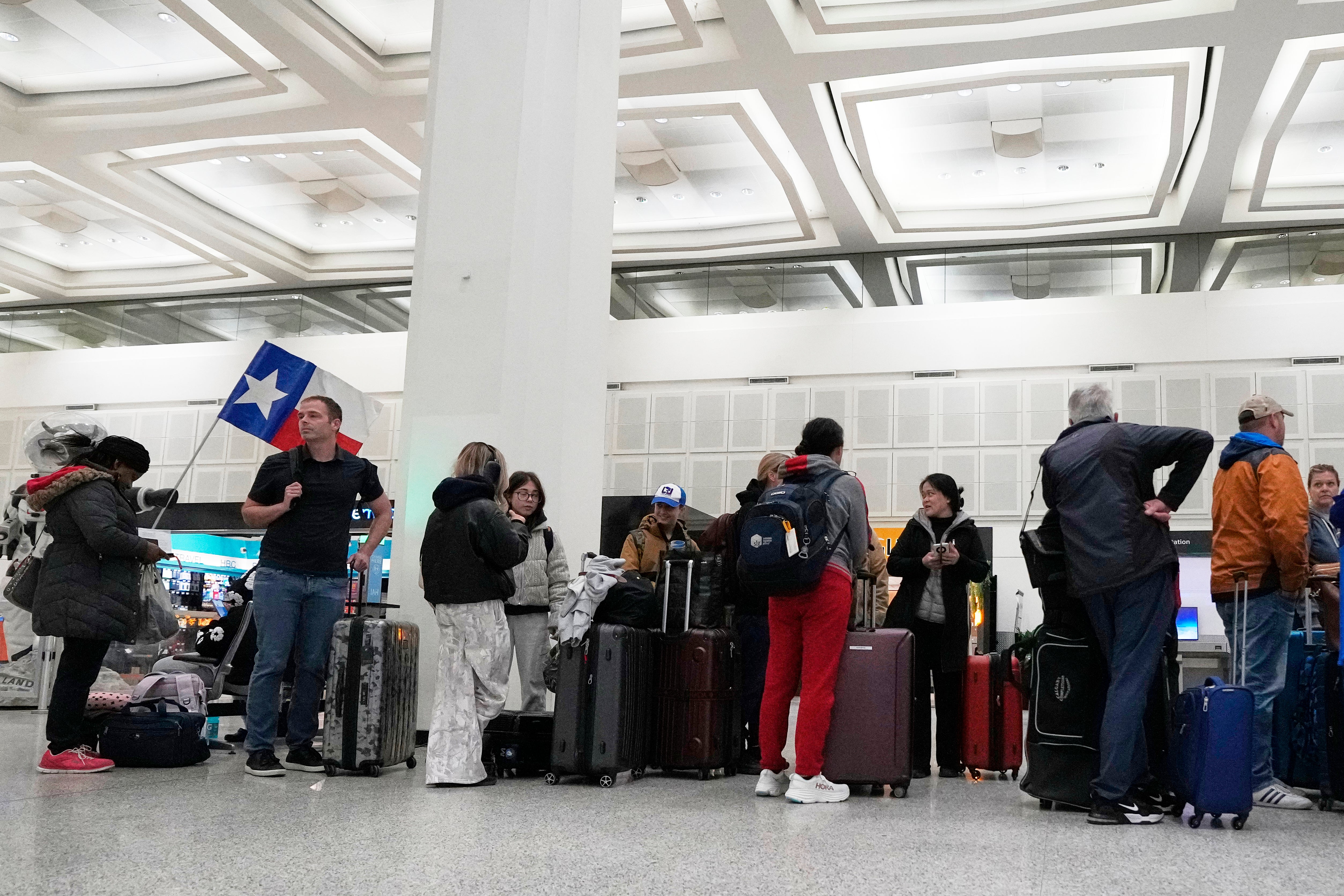 Los pasajeros esperan para registrarse para un vuelo en el Aeropuerto Intercontinental George Bush en Houston el lunes. Los vuelos en el aeropuerto fueron suspendidos temporalmente el martes. Más de 220 millones de estadounidenses se enfrentan a resfriados graves y peligrosos esta semana