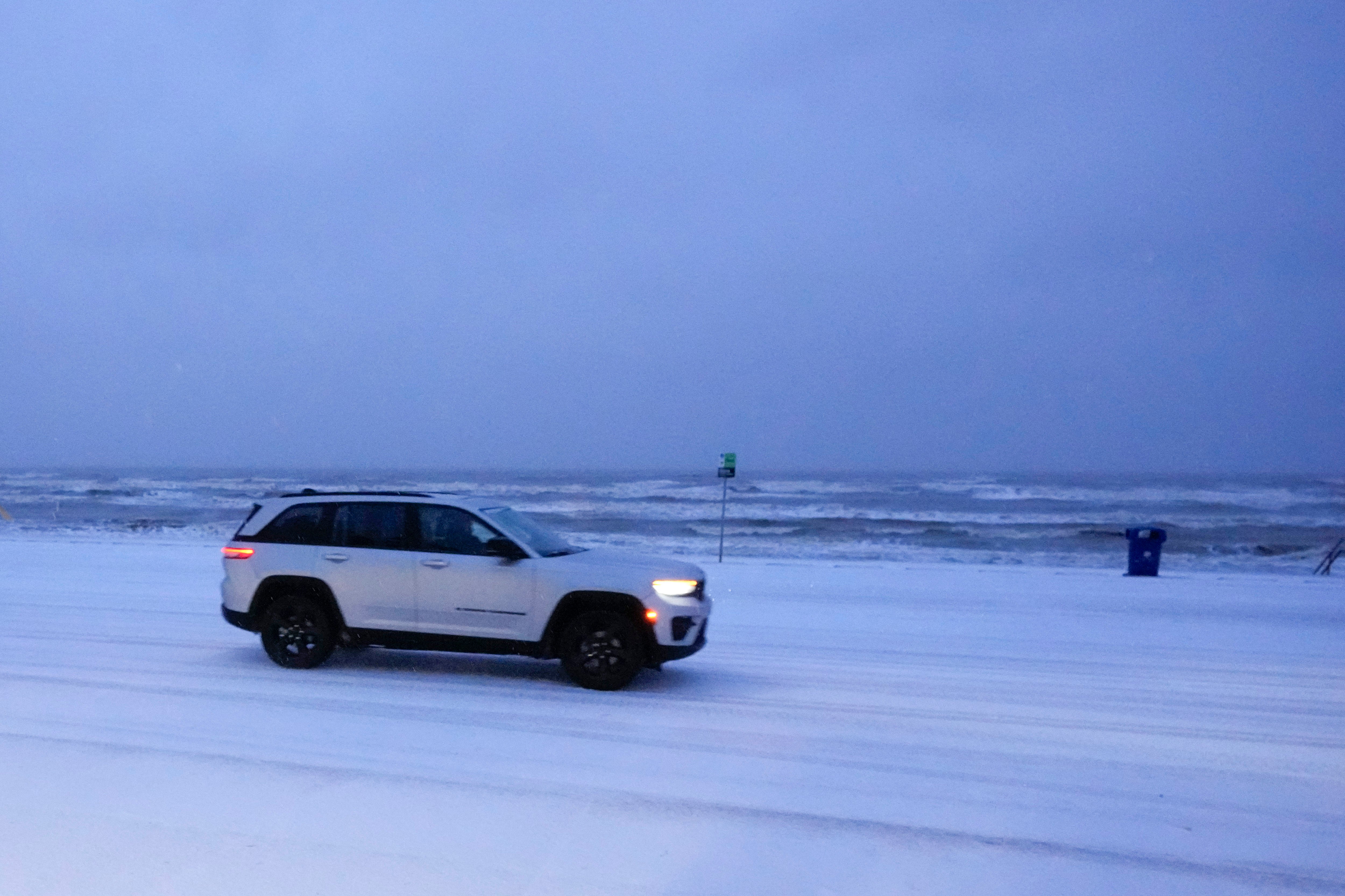 Una camioneta conduce por una carretera cubierta de nieve durante una tormenta invernal helada en Galveston, Texas, el martes. El sureste siente los efectos de una rara tormenta invernal