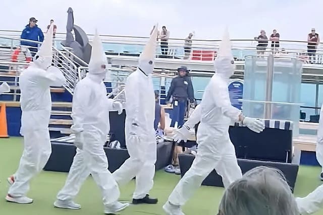 <p>Staff members were pictured wearing all-white boiler suits and pointed white masks onboard <em>Pacific Explorer</em></p>