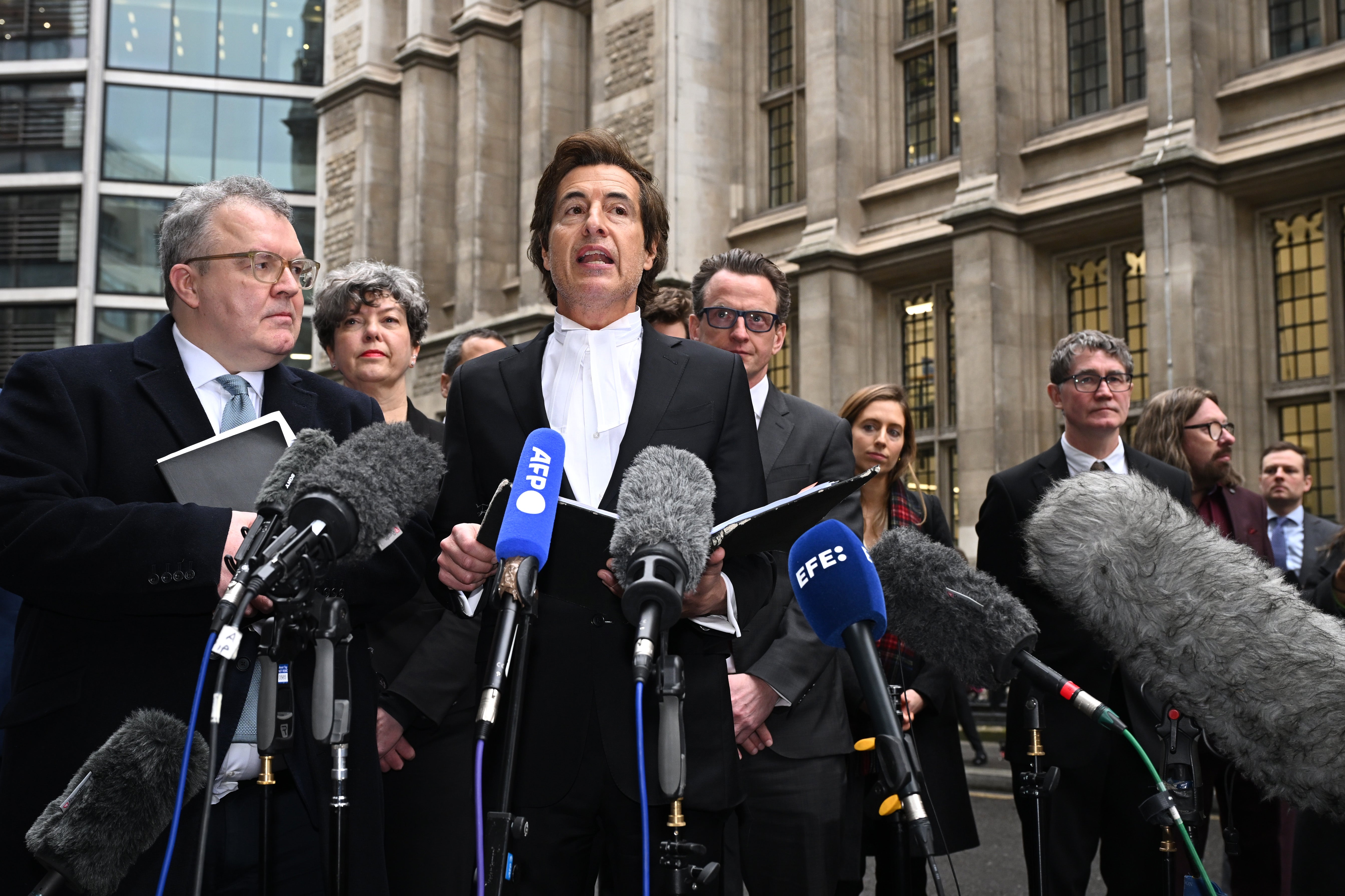 Barrister David Sherborne stands next to Watson as he speaks to the media outside the High Court on Wednesday