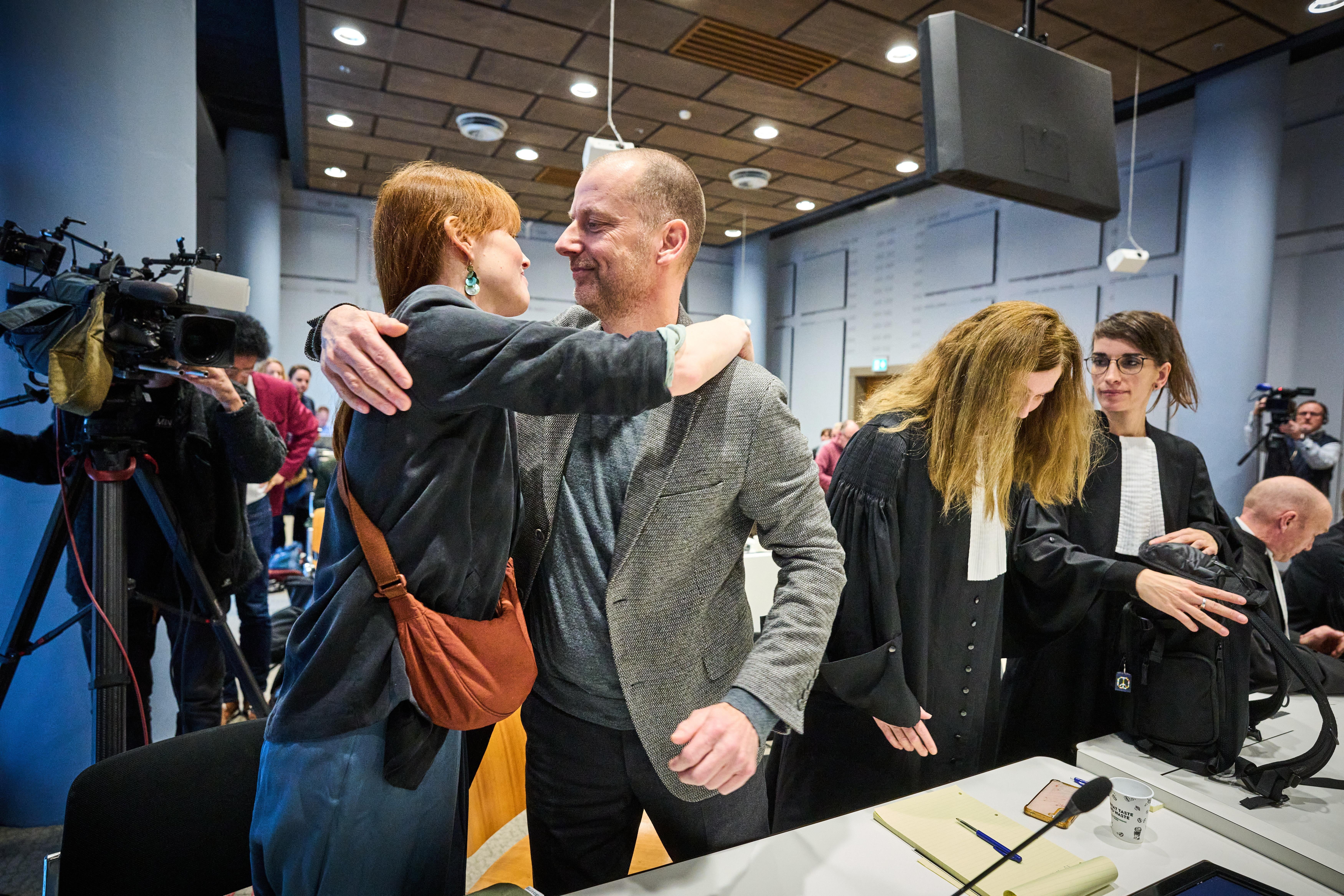 Director Andy Palmen of Greenpeace Netherlands embraces campaigner Hilde-Anna de Vries in the court in The Hague