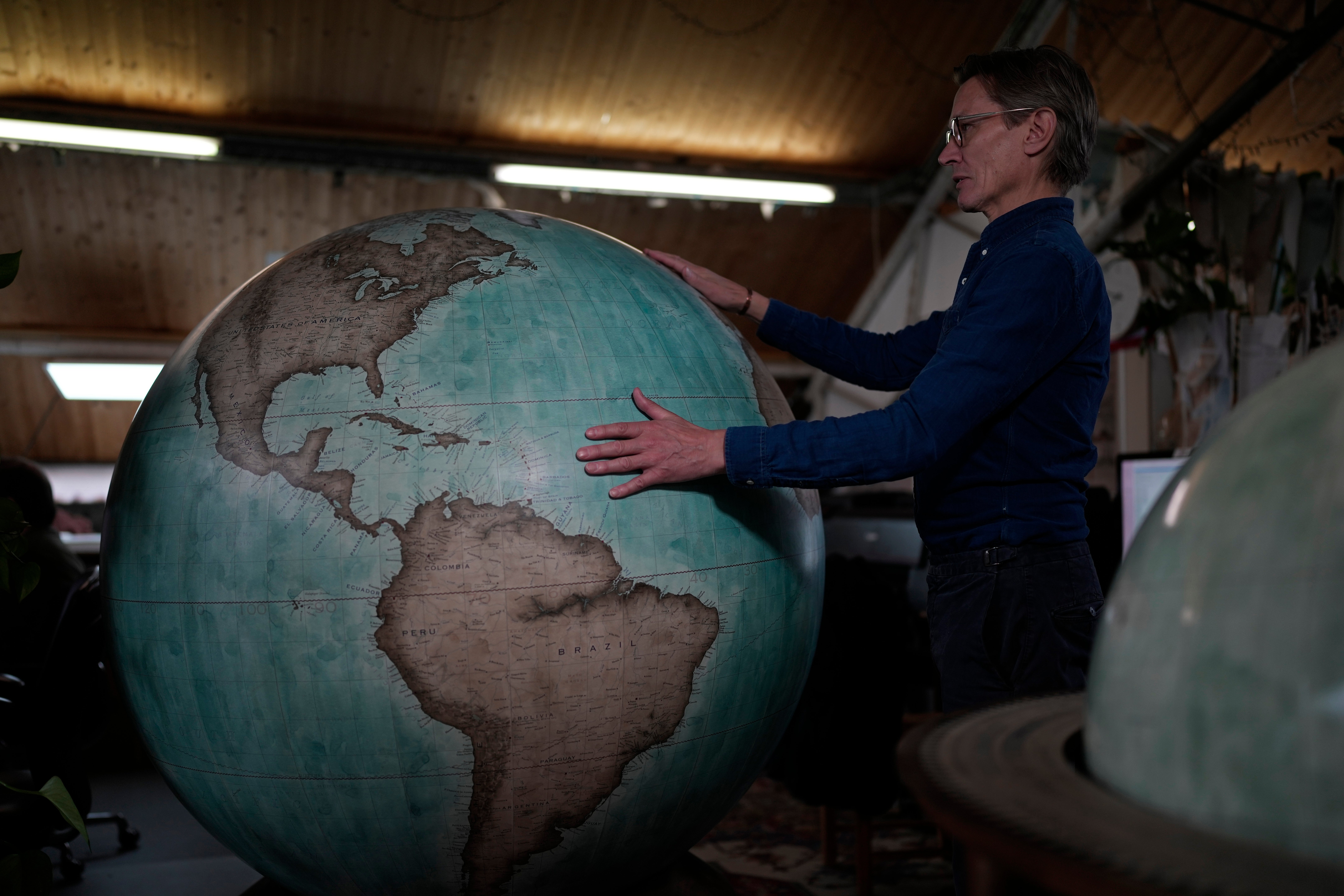 Peter Bellerby, the founder of Bellerby & Co. Globemakers, holds a globe at a studio in London