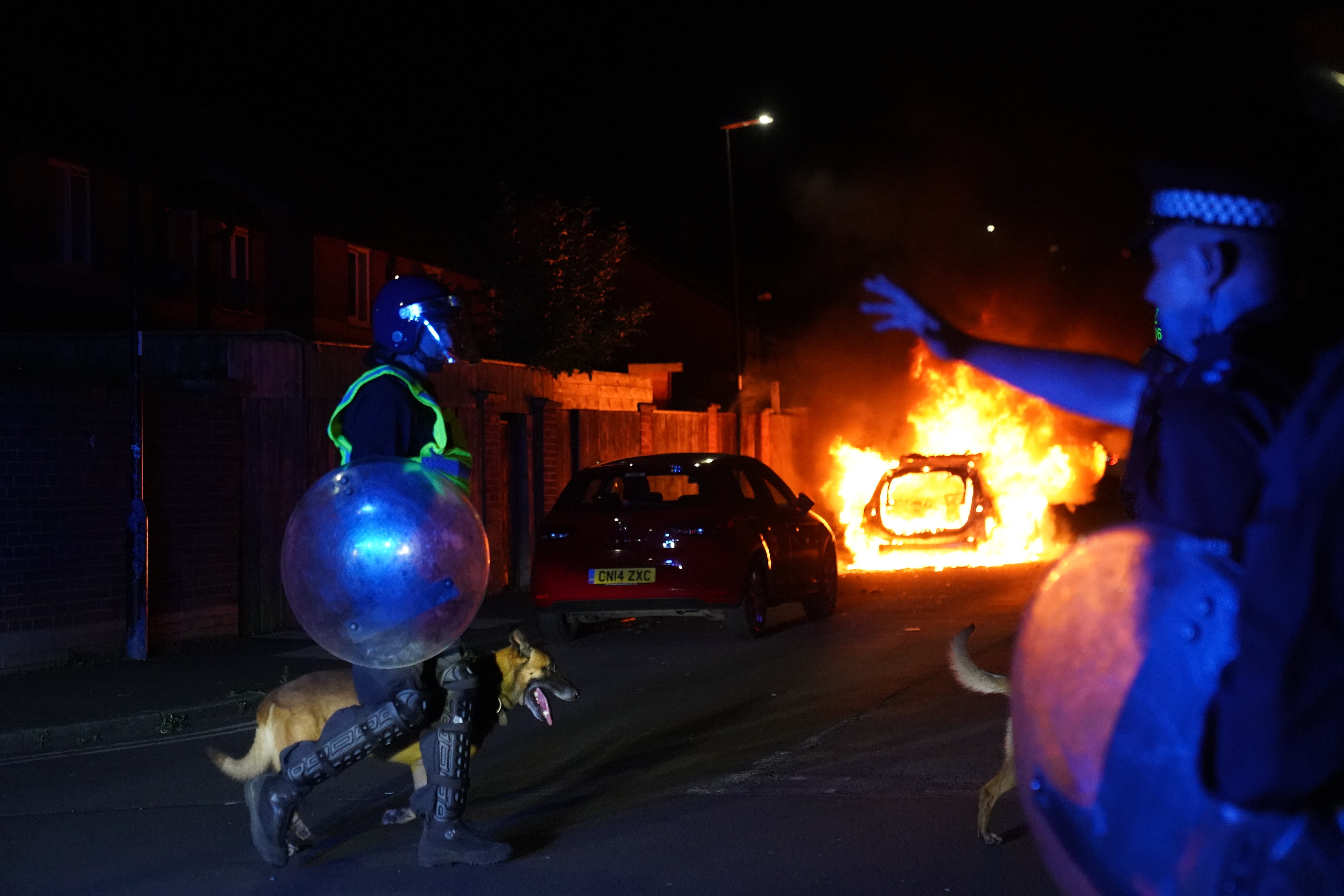 A police car burns as officers are deployed on the streets of Hartlepool following a violent protest at the end of July
