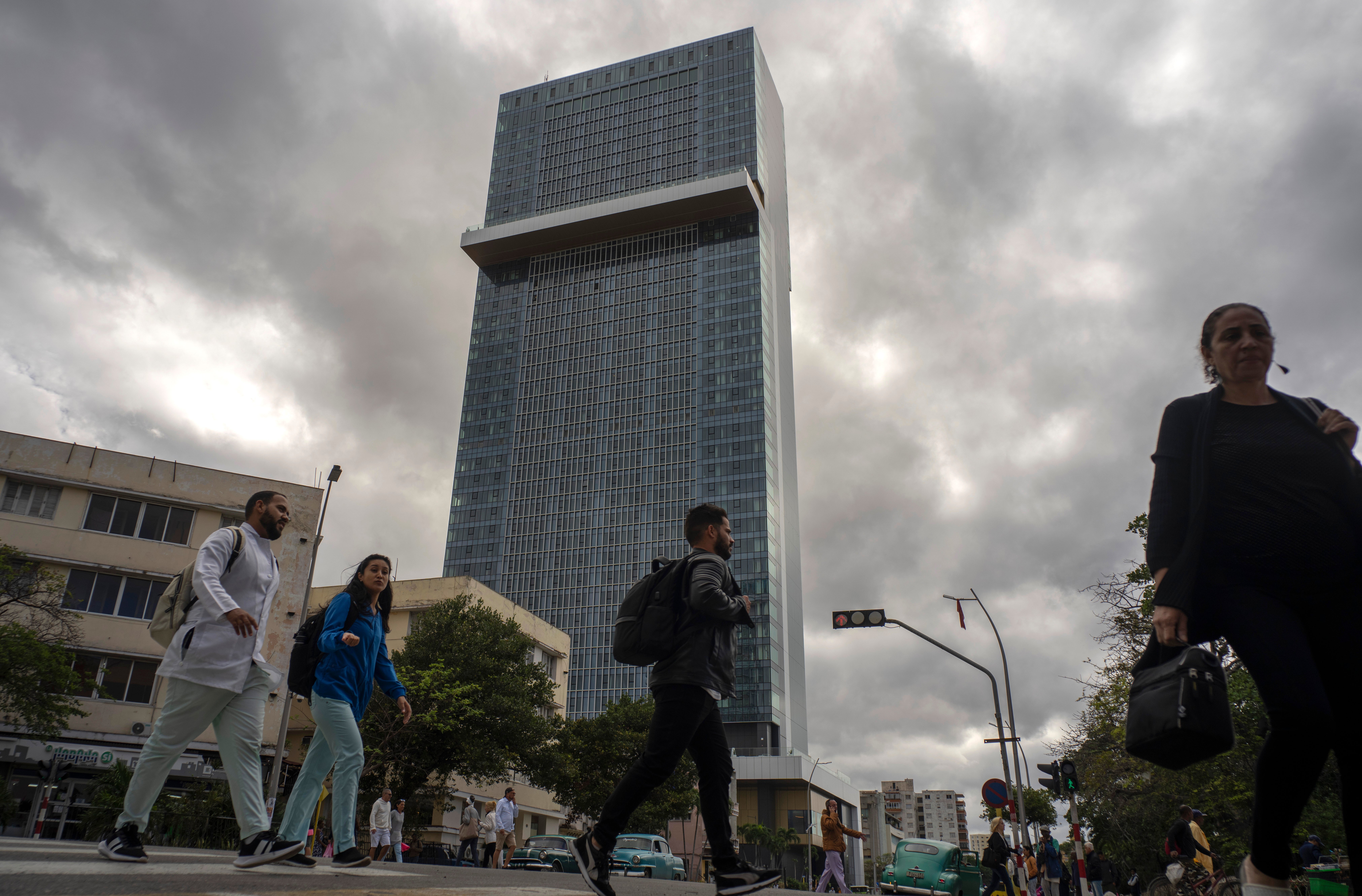 People walk past the Selection La Habana new hotel, managed by Spanish chain Iberostar, in Havana, Cuba, Friday, Jan. 24, 2025