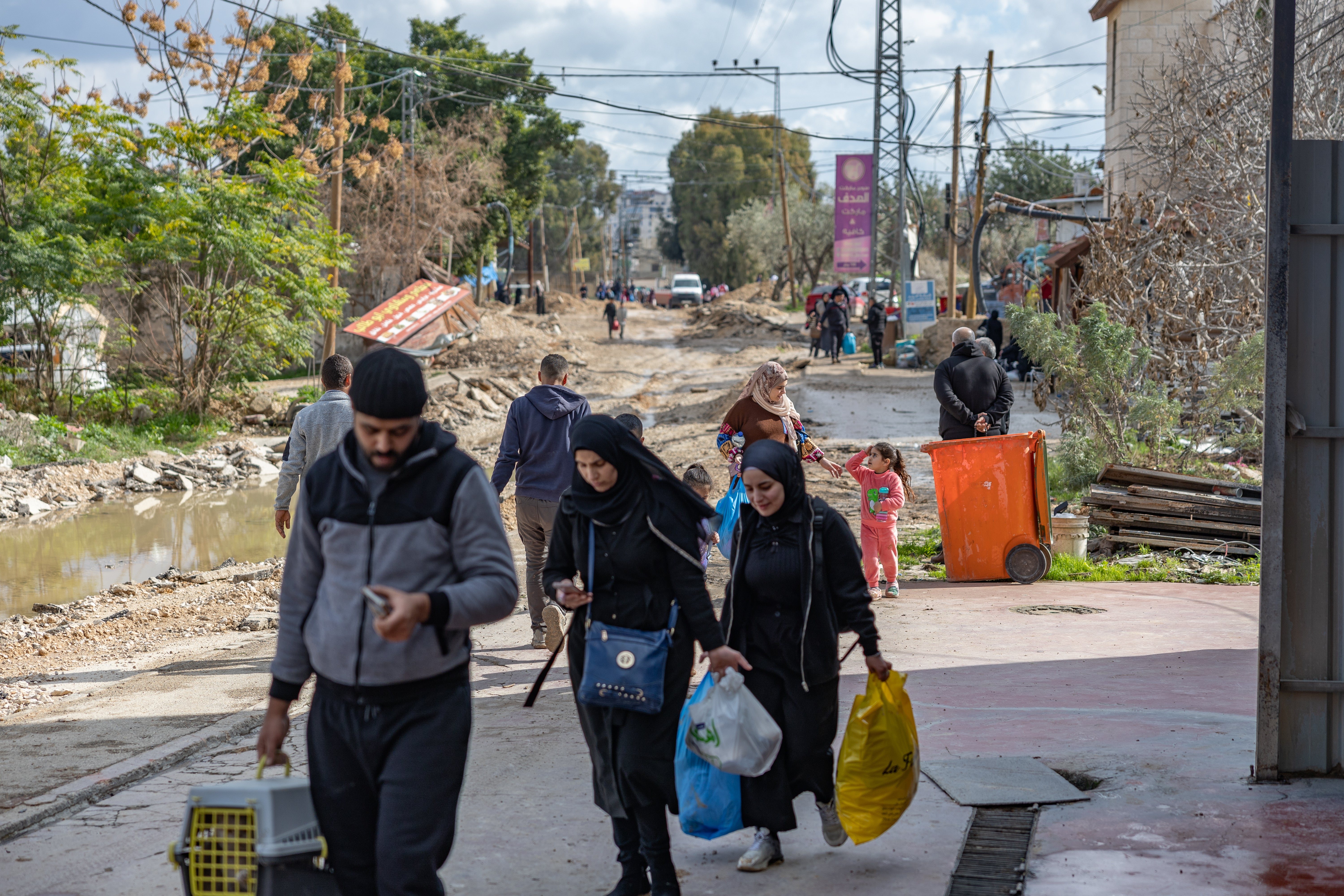 Families fleeing Jenin via a dirt road chewed up by bulldozers