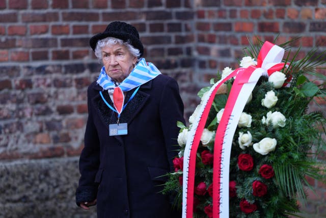 <p>A survivor stands next to the Death Wall on the 80th anniversary of the liberation of  Auschwitz-Birkenau concentration camp </p>