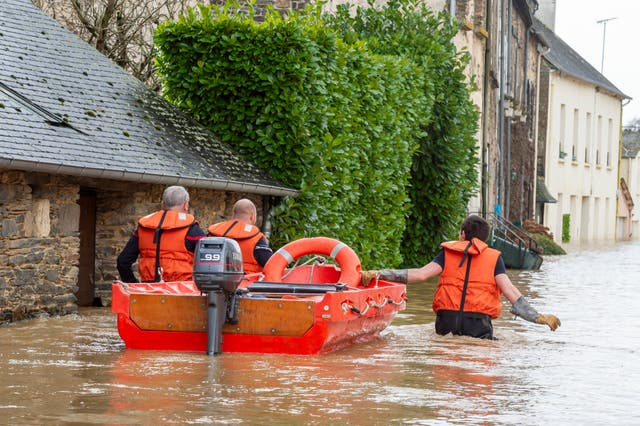 <p>Rescue workers pull a small boat after the storm Herminia has unleashed downpours on the region</p>