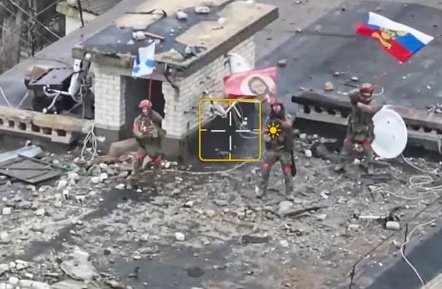 <p>A still image taken from a handout video provided by the Russian Defence Ministry shows Russian servicemen waving flags on the roof of a building in Velyka Novosilka, Donetsk region</p>