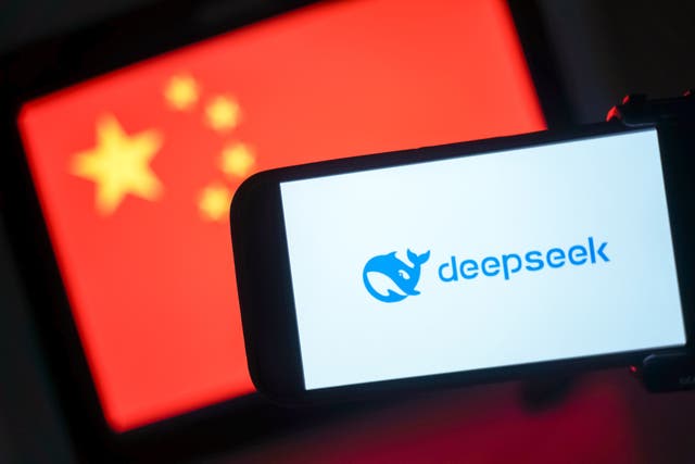 <p>DeepSeek logo is seen on a phone in front of a flag of China</p>