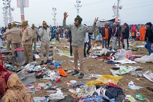 <p>A policeman gestures as the belongings of Hindu devotees lie scattered after a stampede when Hindu devotees rushed to take a holy bath in the Sangam, the confluence of the Ganges</p>