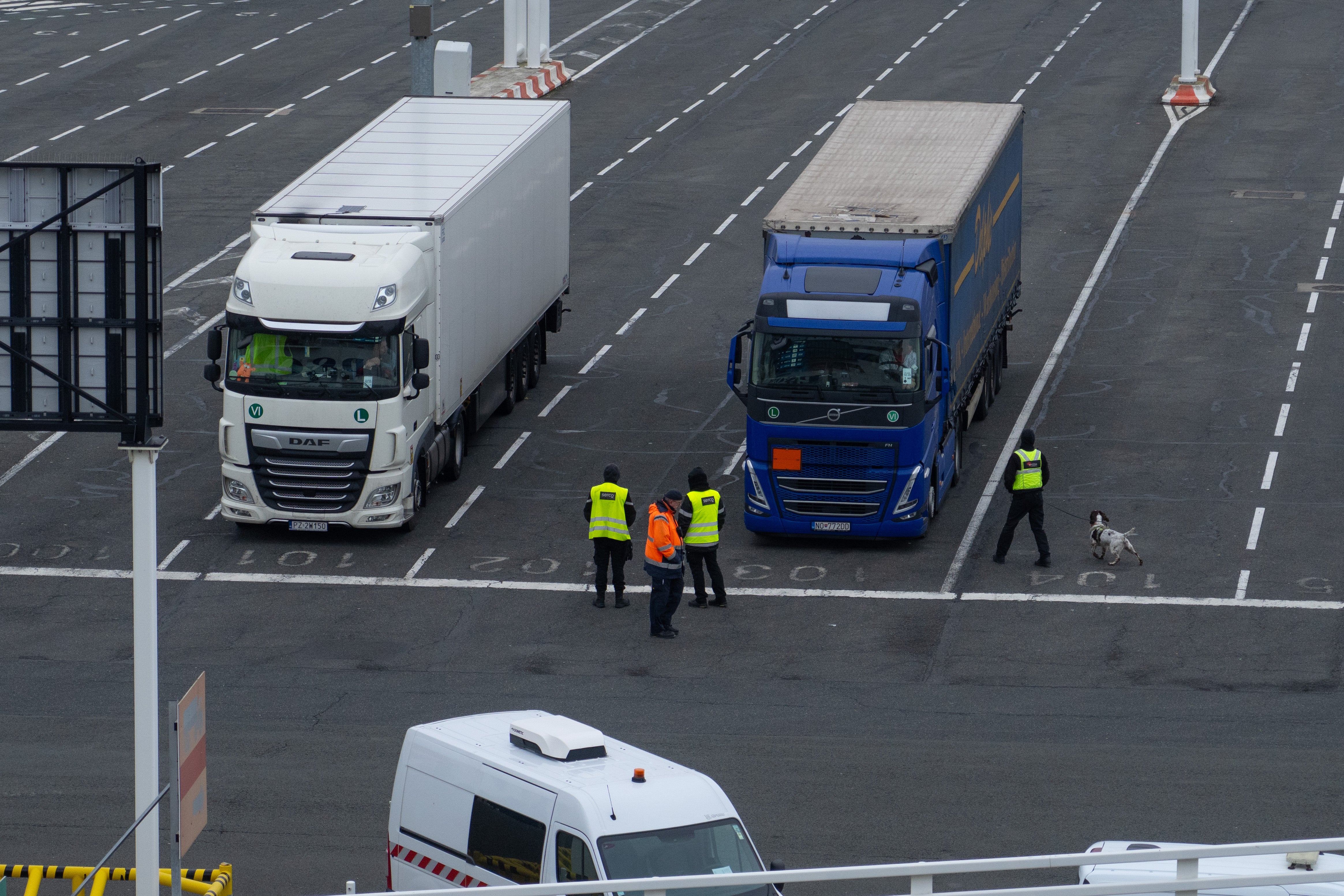 A sniffer dog operated by Serco private security guards checks trucks waiting to board a cross-Channel ferry in Calais