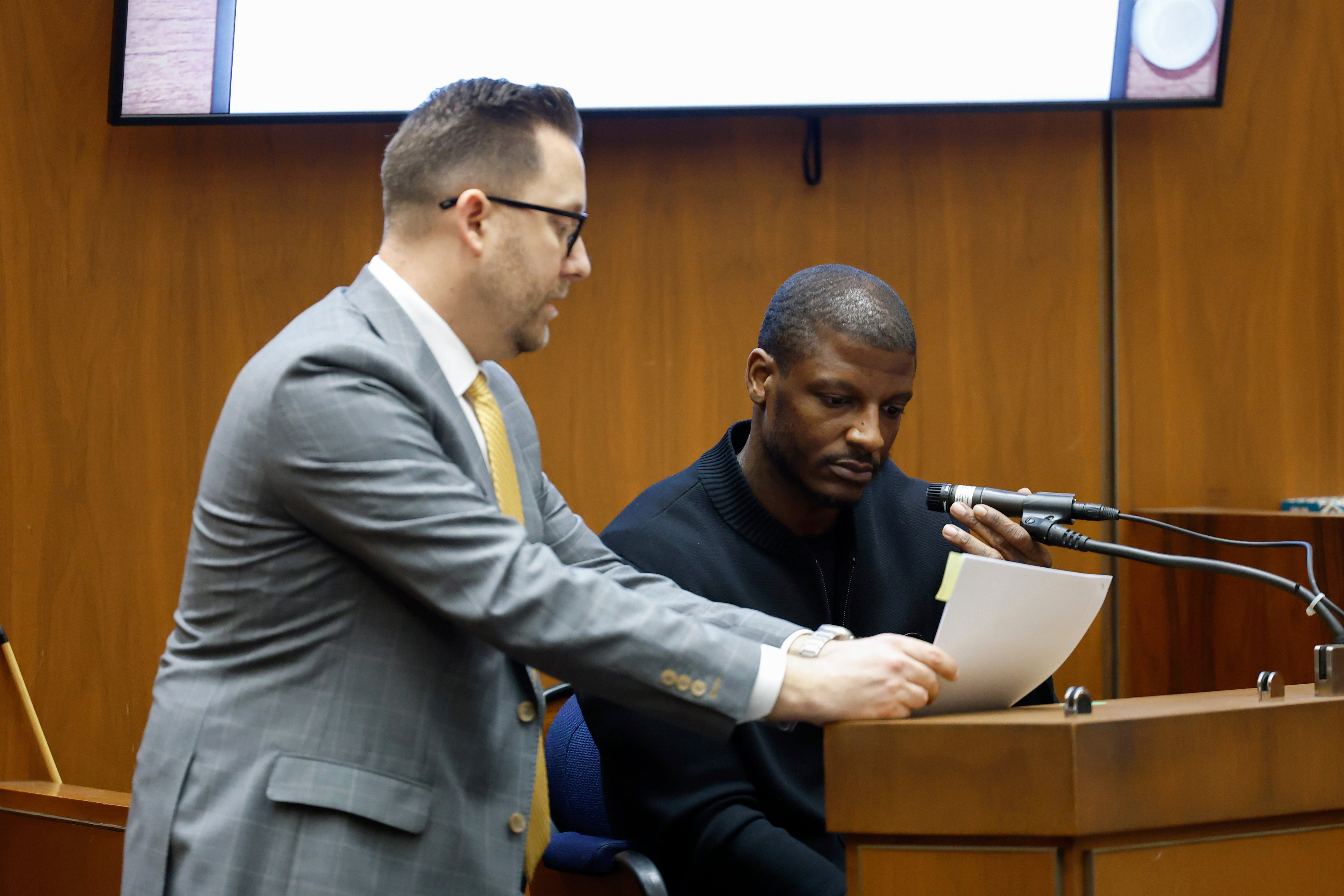 Los Angeles County Deputy District Attorney Paul Przelomiec, left, shows a document to A$AP Relli during A$AP Rocky’s trial