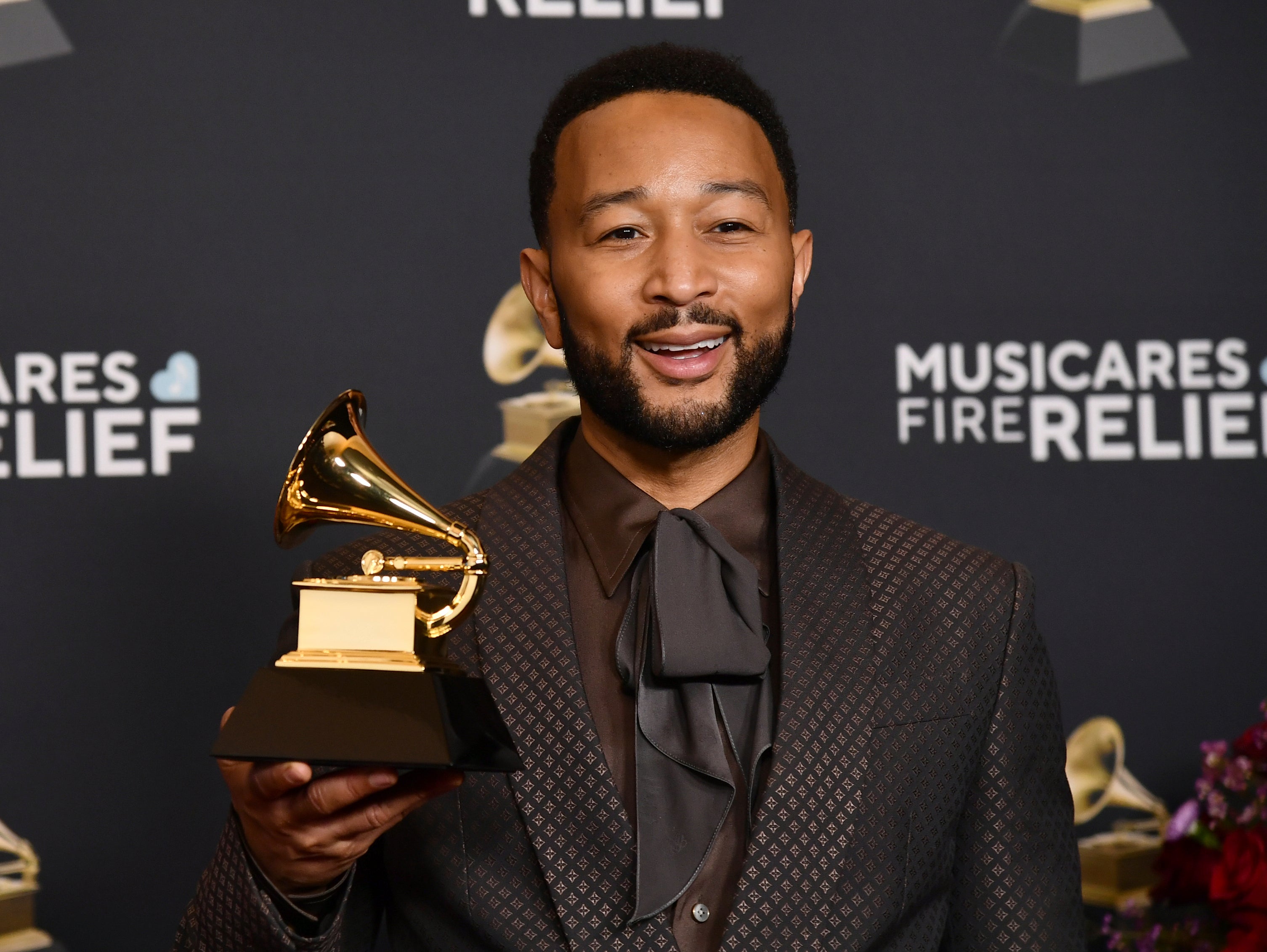John Legend poses in the press room with the award for best arrangement, instrumental or a cappella during the 67th annual Grammy Awards on Sunday, Feb. 2, 2025, in Los Angeles.