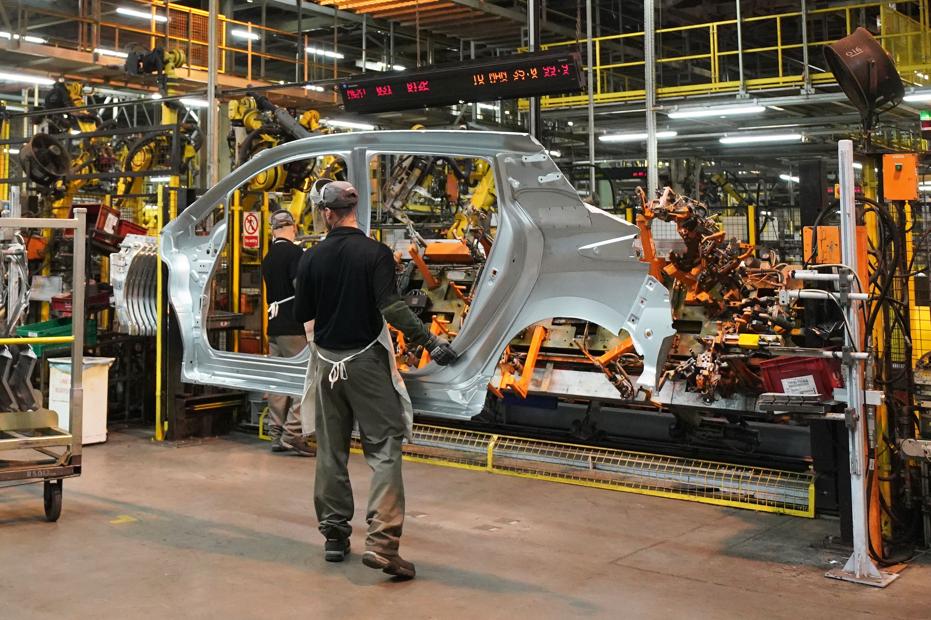 Workers on the production line at a car factory (Owen Humphreys/PA)