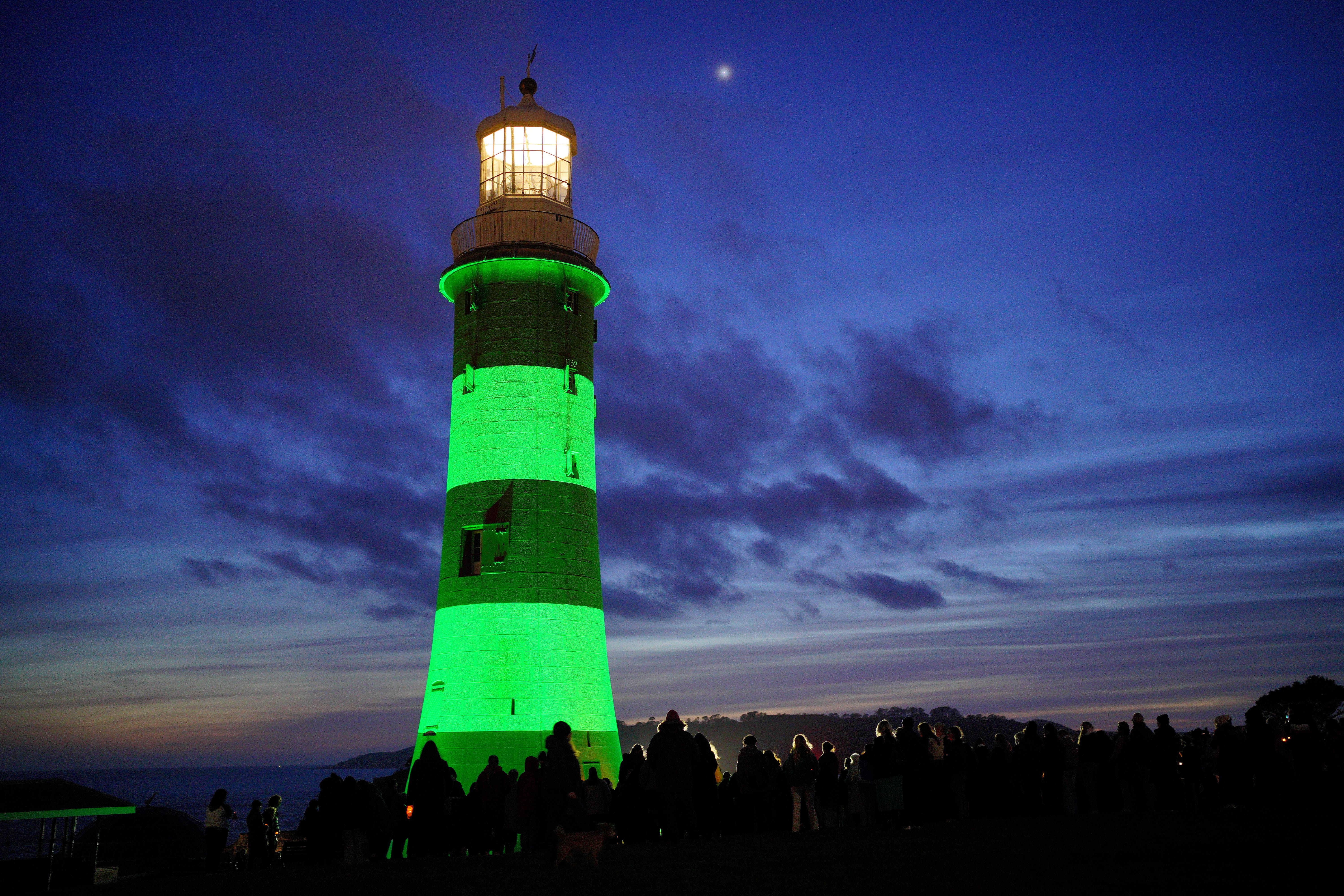 Smeaton’s Tower lighthouse is lit up green (Ben Birchall/PA)