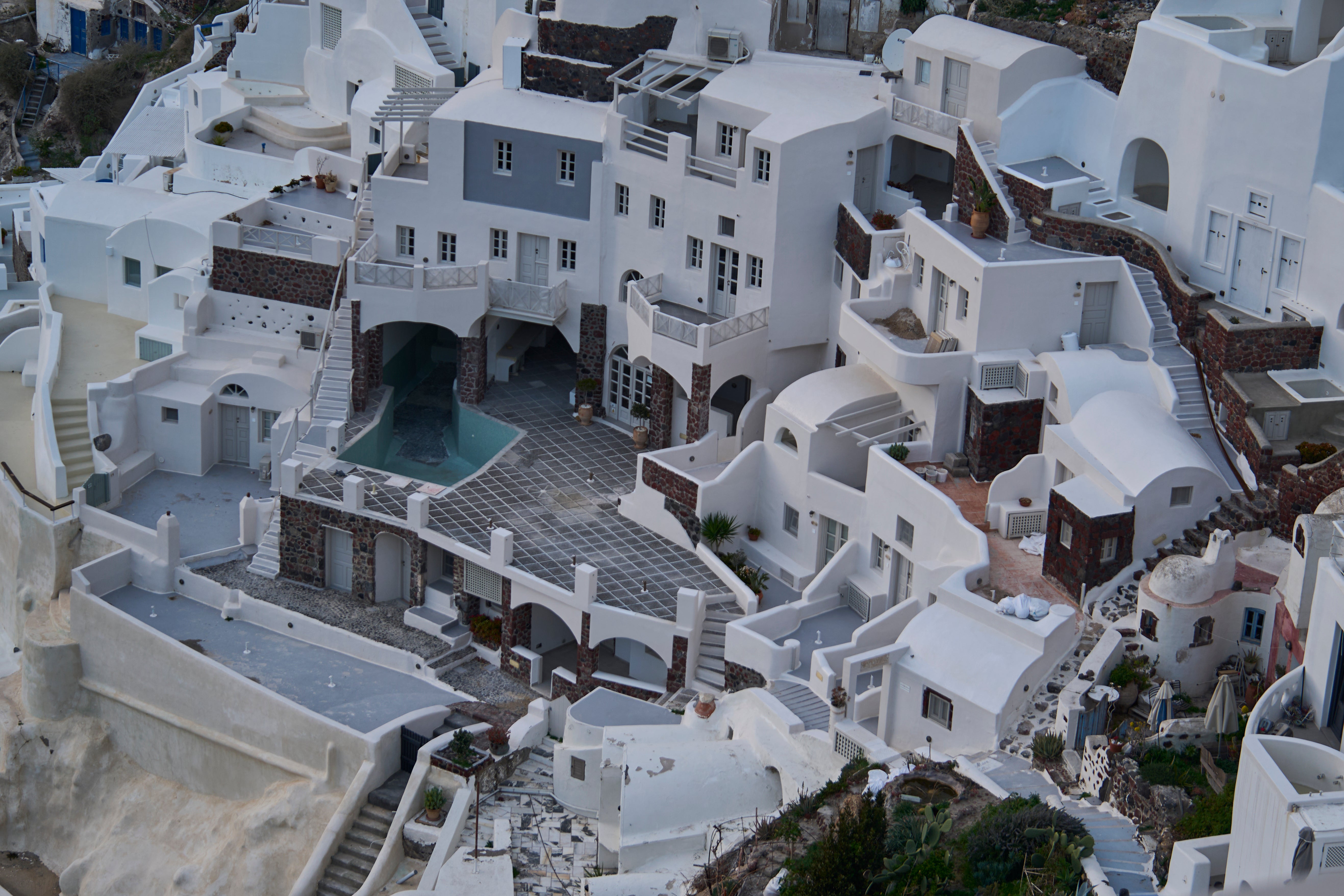 An empty swimming pool is seen in a group of clifftop buildings in the town of Oia on the earthquake-struck island of Santorini