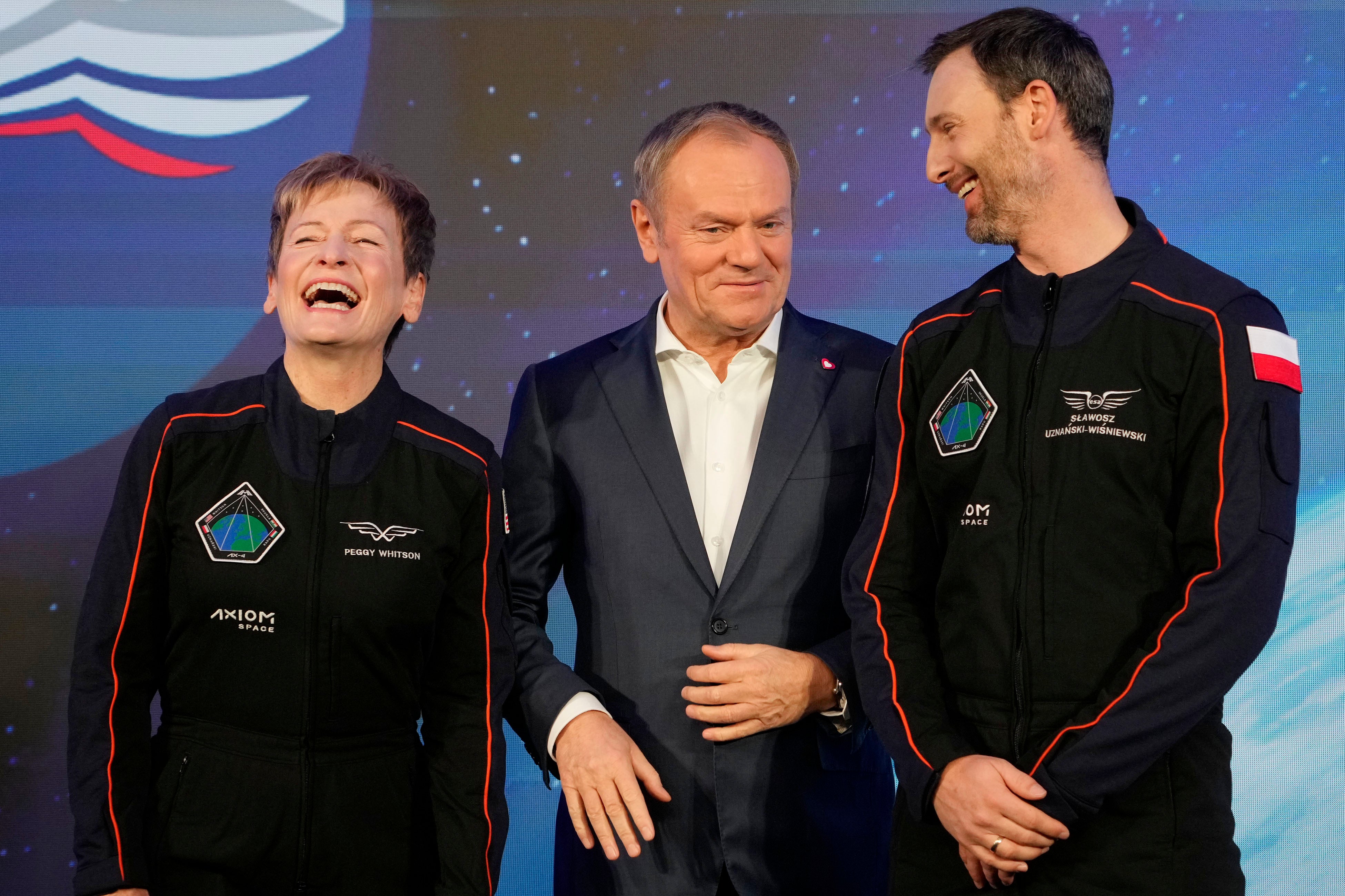U.S. astronaut Peggy Whitson, commander of the Ax-4 space mission, left, Poland's Prime Minister Donald Tusk, center, and Polish member of the mission crew, astronaut Slawosz Uznanski-Wisniewski, right, pose during a media event dedicated to the preparations for the mission, at the Copernicus Science Center in Warsaw