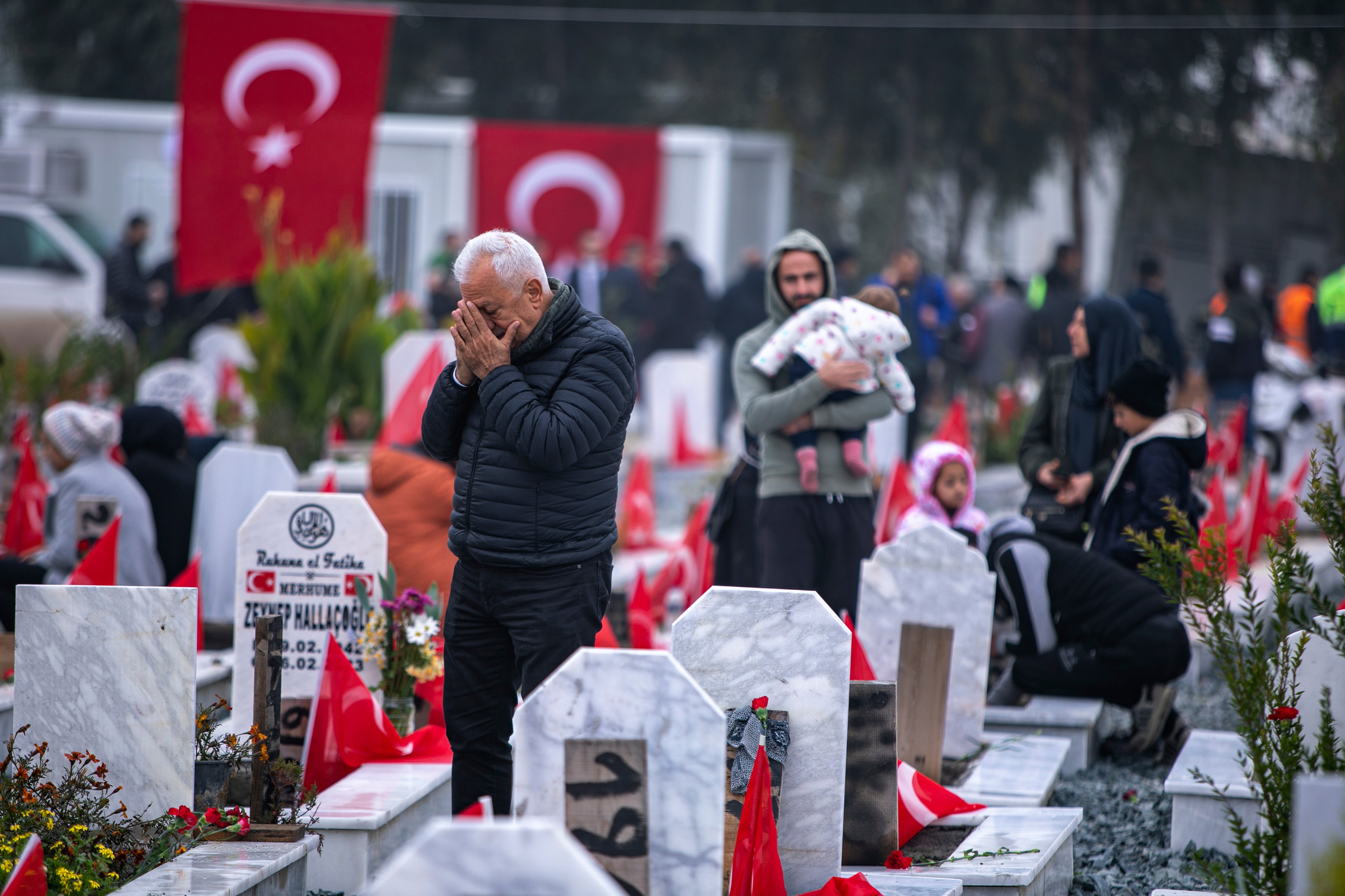File. People visit graves in a cemetery where some of the victims of the February 2023 earthquake are buried in Antakya, Turkey