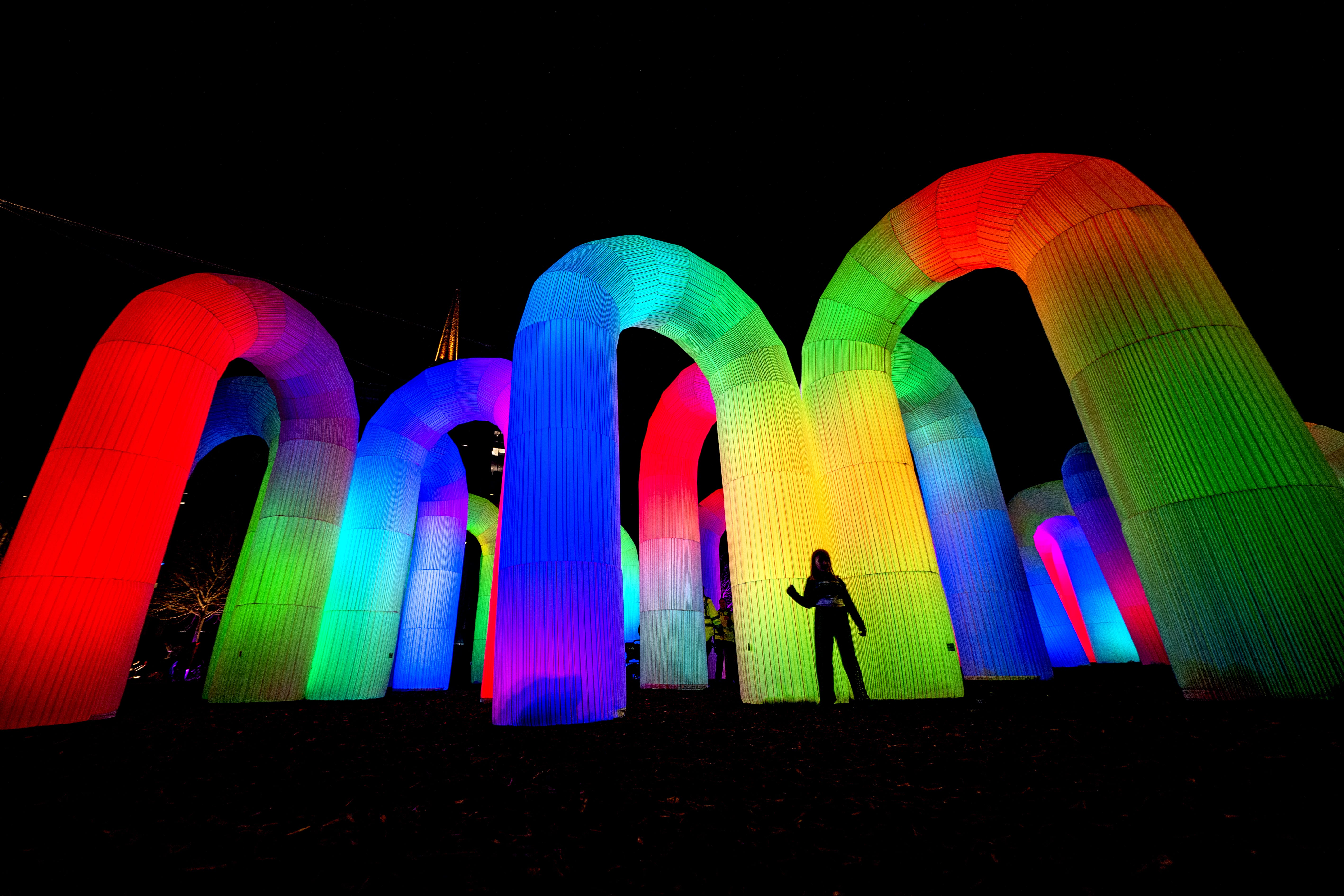 Visitors explore the Sky Castle, an interactive sound and light installation featuring huge inflatable arches at the Spectra festival (Jane Barlow/PA)