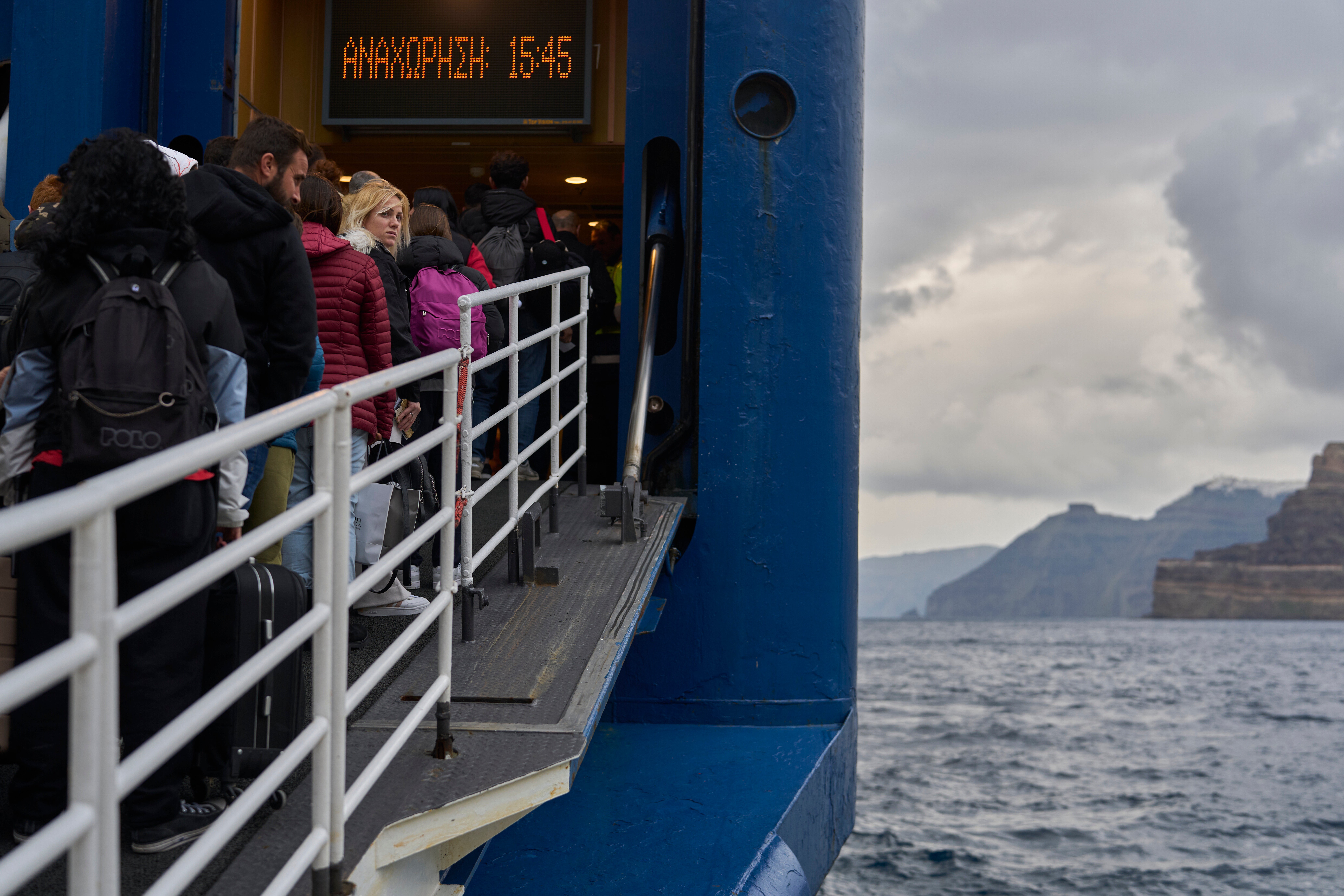 Passengers board a ferry bound for the Greek mainland, in the earthquake-struck island of Santorini