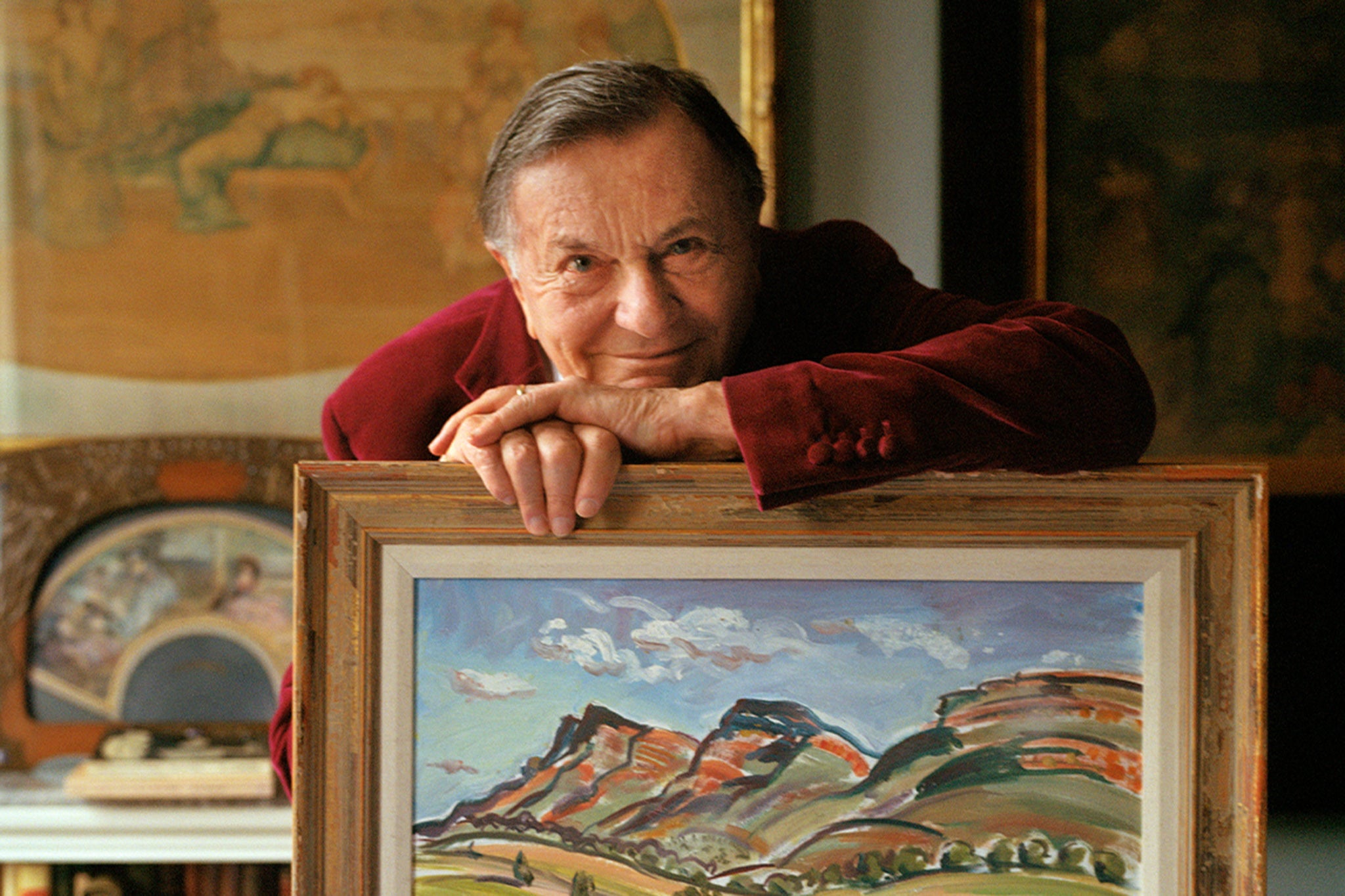 Barry Humphries at home in 2021 with one of his many artworks