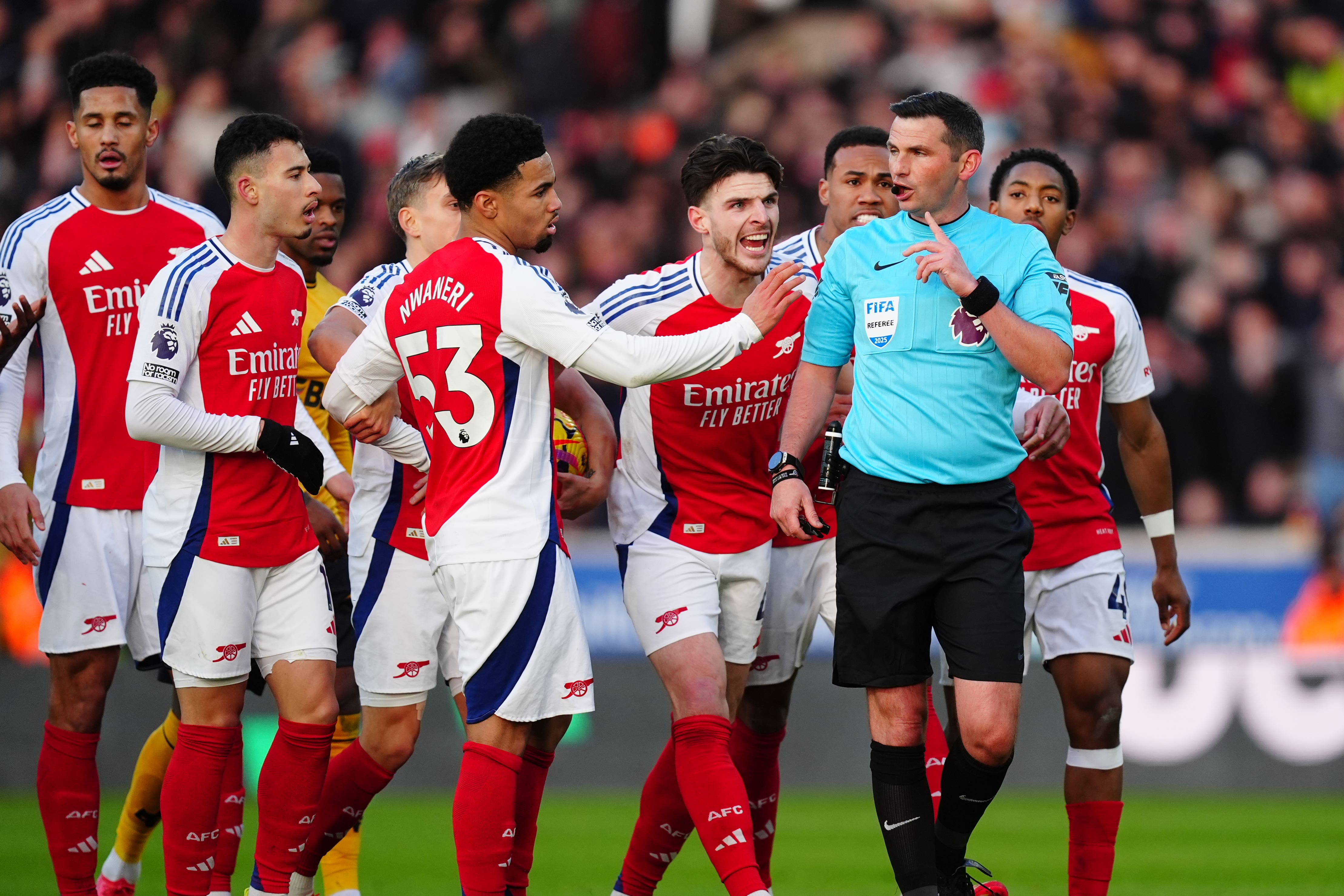 Referee Michael Oliver was confronted by Arsenal’s players after his decision to send off Myles Lewis-Skelly, right, at Molineux (Mike Egwerton/PA)