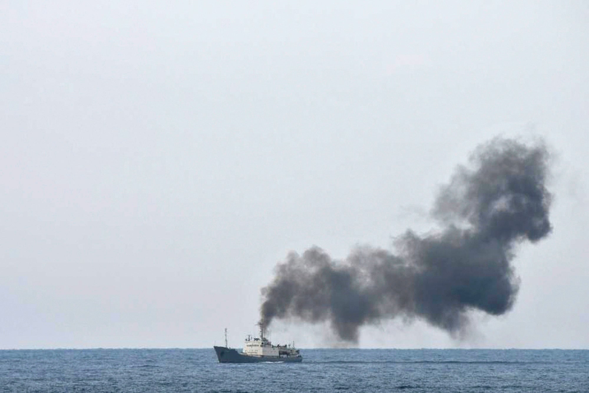 Military officials say this photo taken from a nearby vessel shows smoke rising from a fire aboard the Russian spy ship