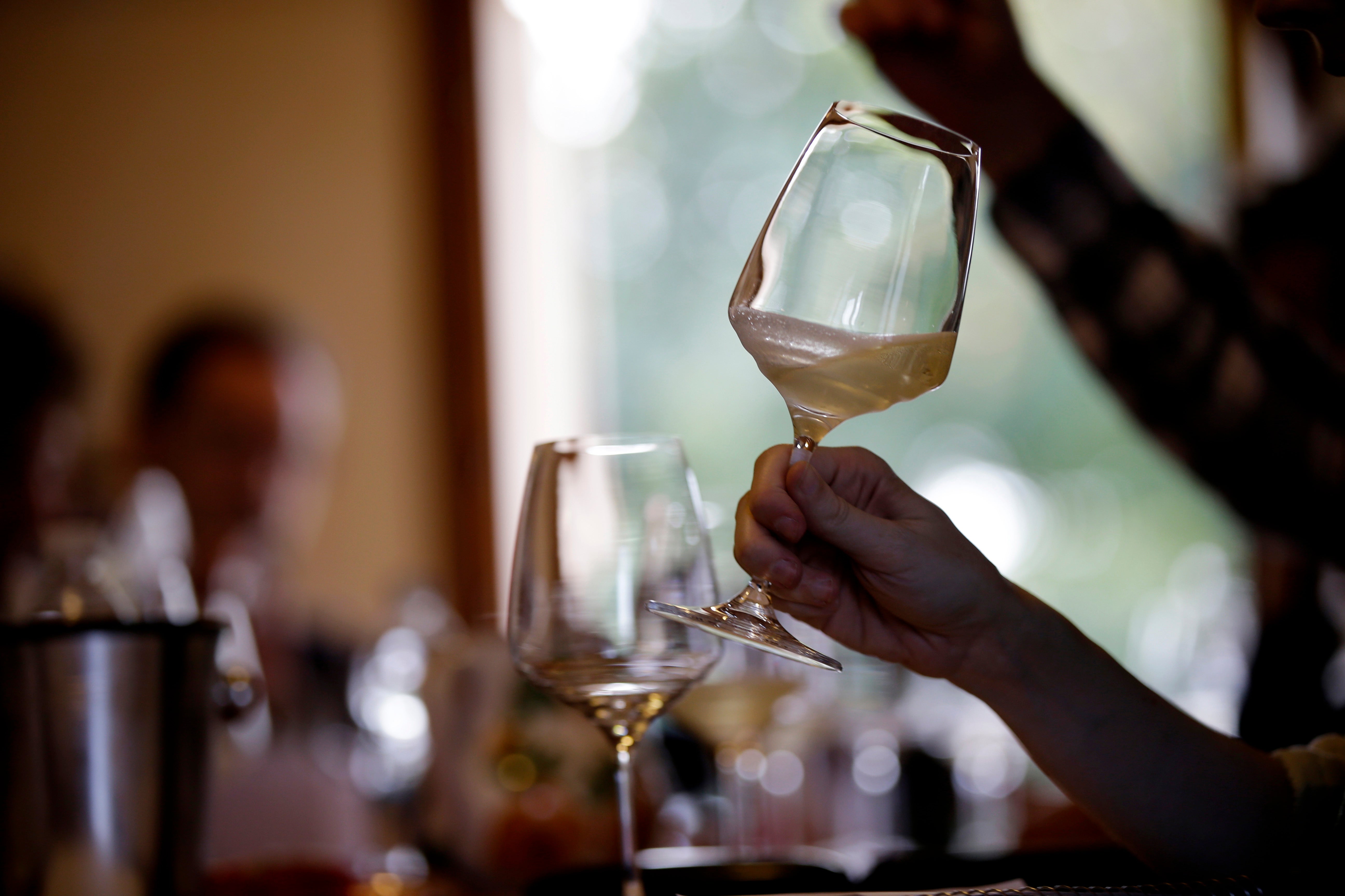 An expert wine tester shakes a glass of Prosecco at the Case Paolin farm in Volpago del Montello, Italy