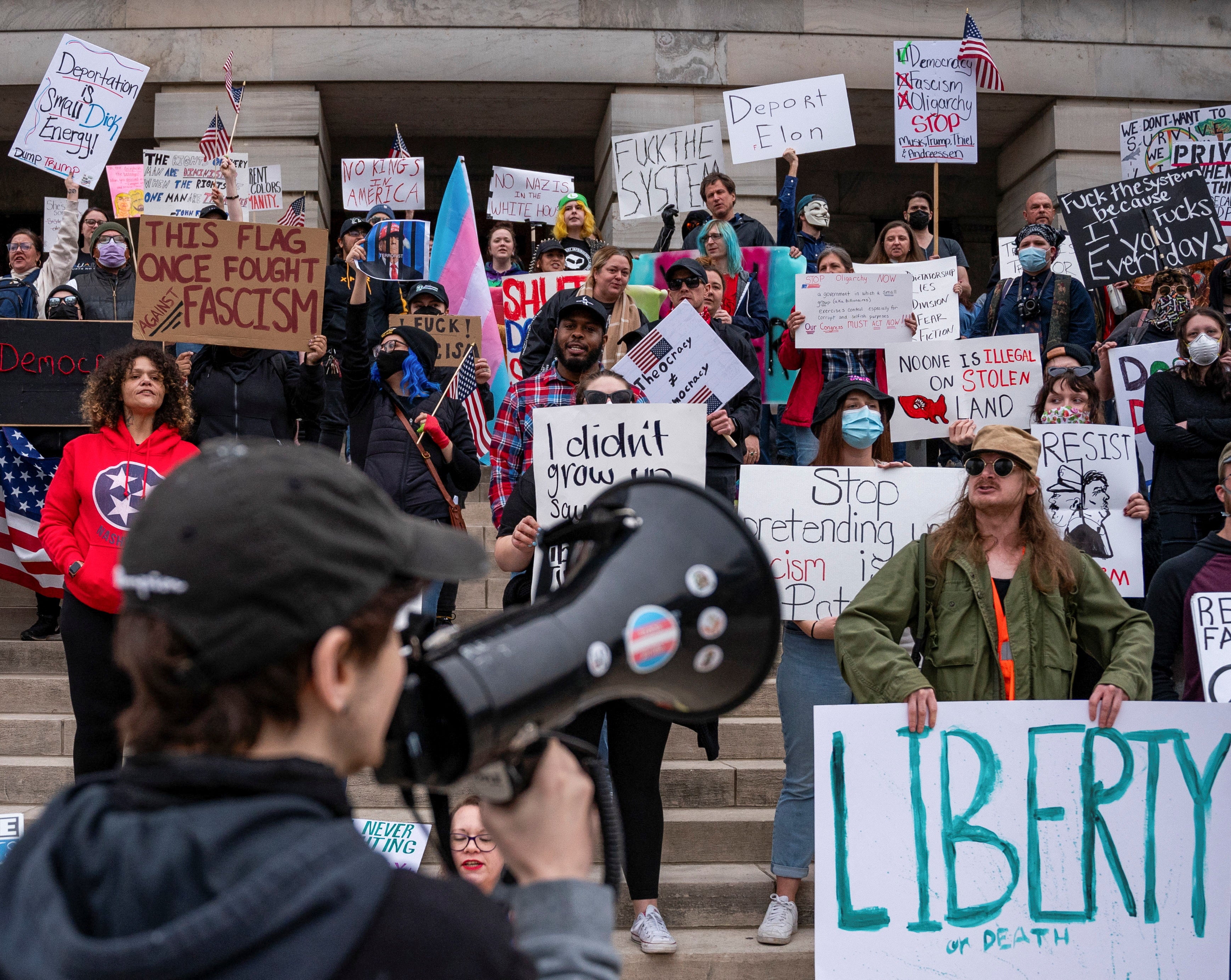 Protesters hold up signs at a 50501 Movement protest against Project 2025 and the executive orders of U.S. President Donald Trump at the Tennessee State Capitol building.