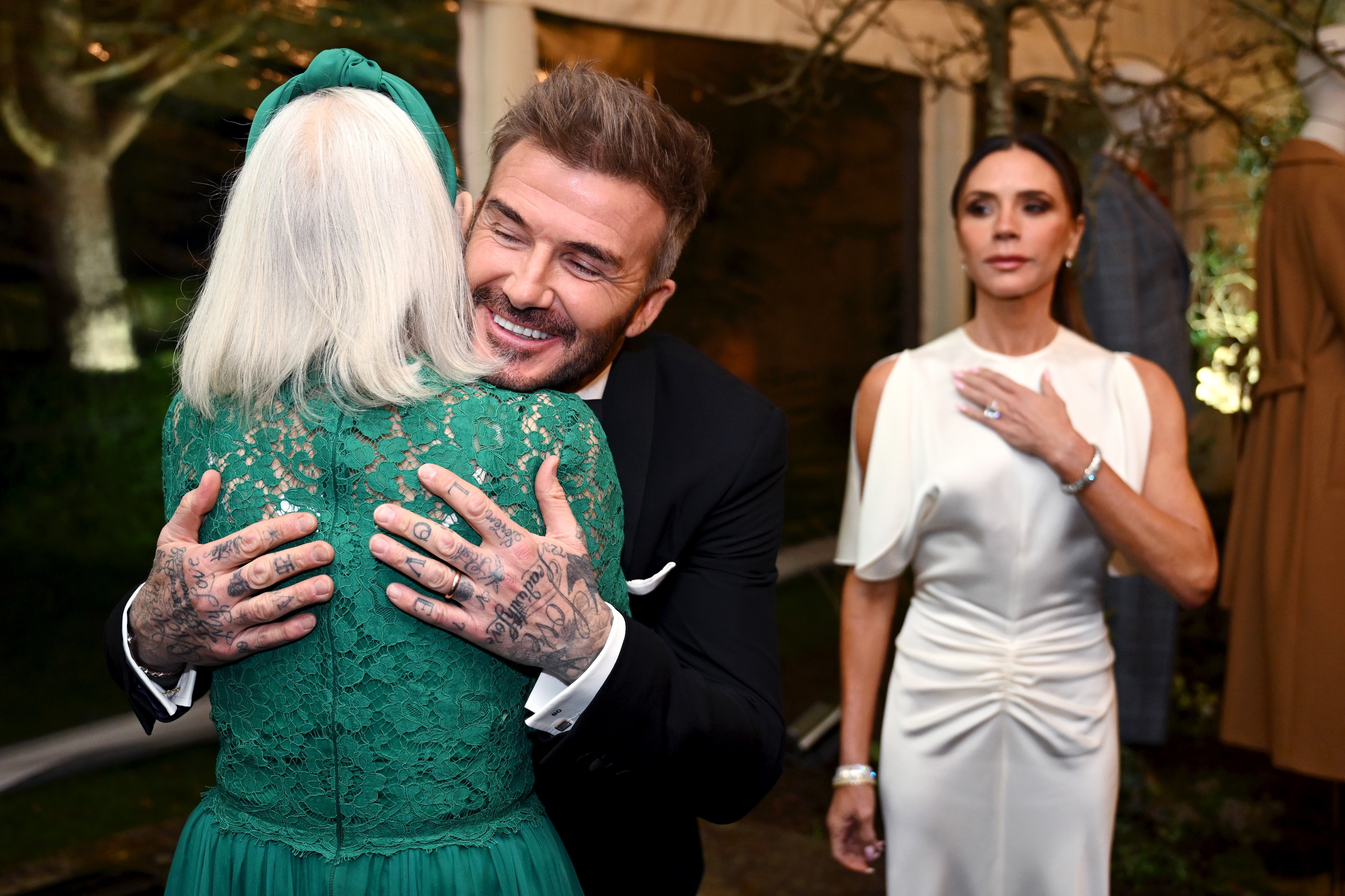 David Beckham hugs actress Dame Helen Mirren at the event