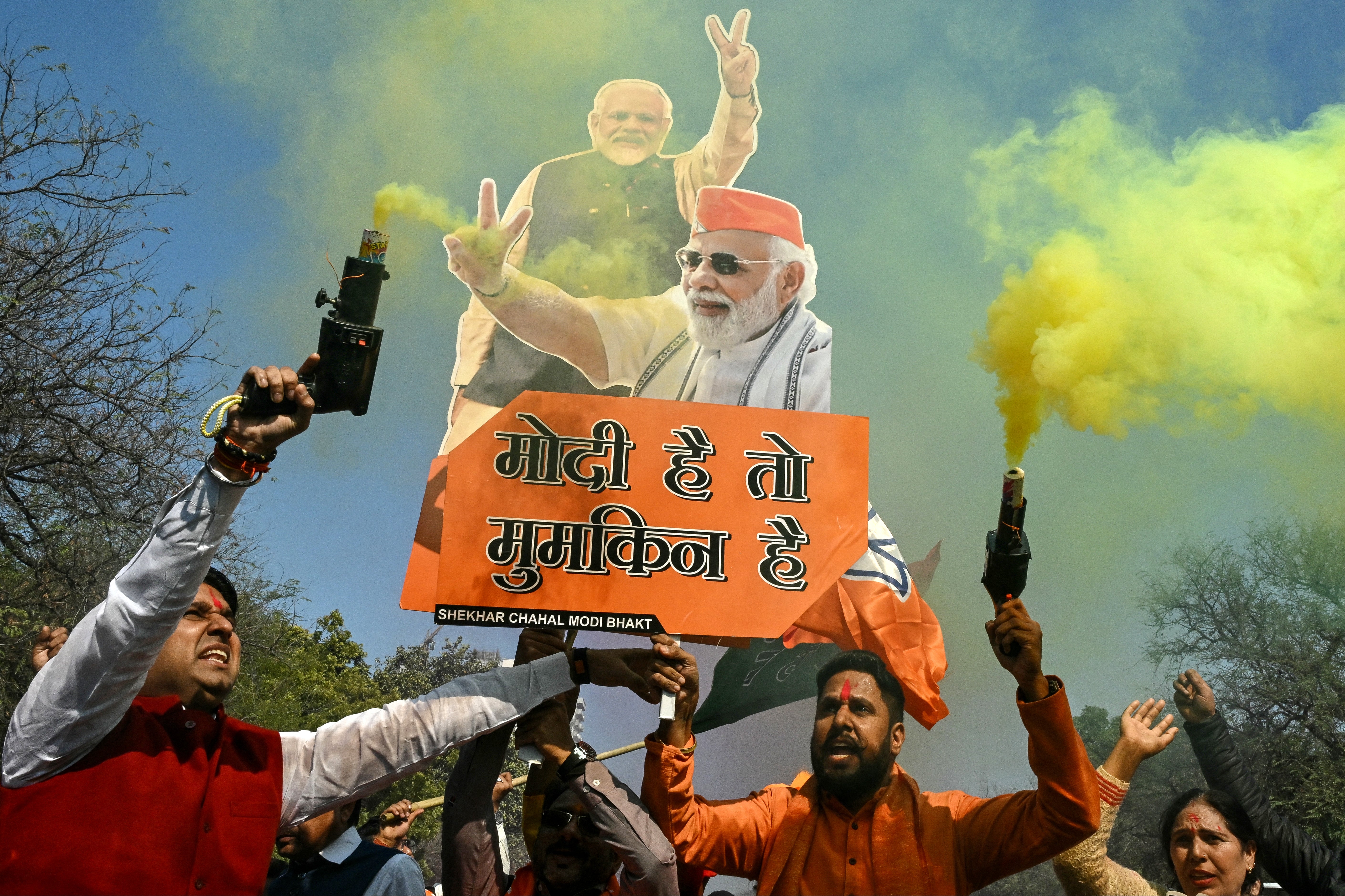 Supporters of the Bharatiya Janata Party (BJP) celebrate as BJP leads in vote counting for the Delhi legislative assembly election outside the party's state headquarters in New Delhi