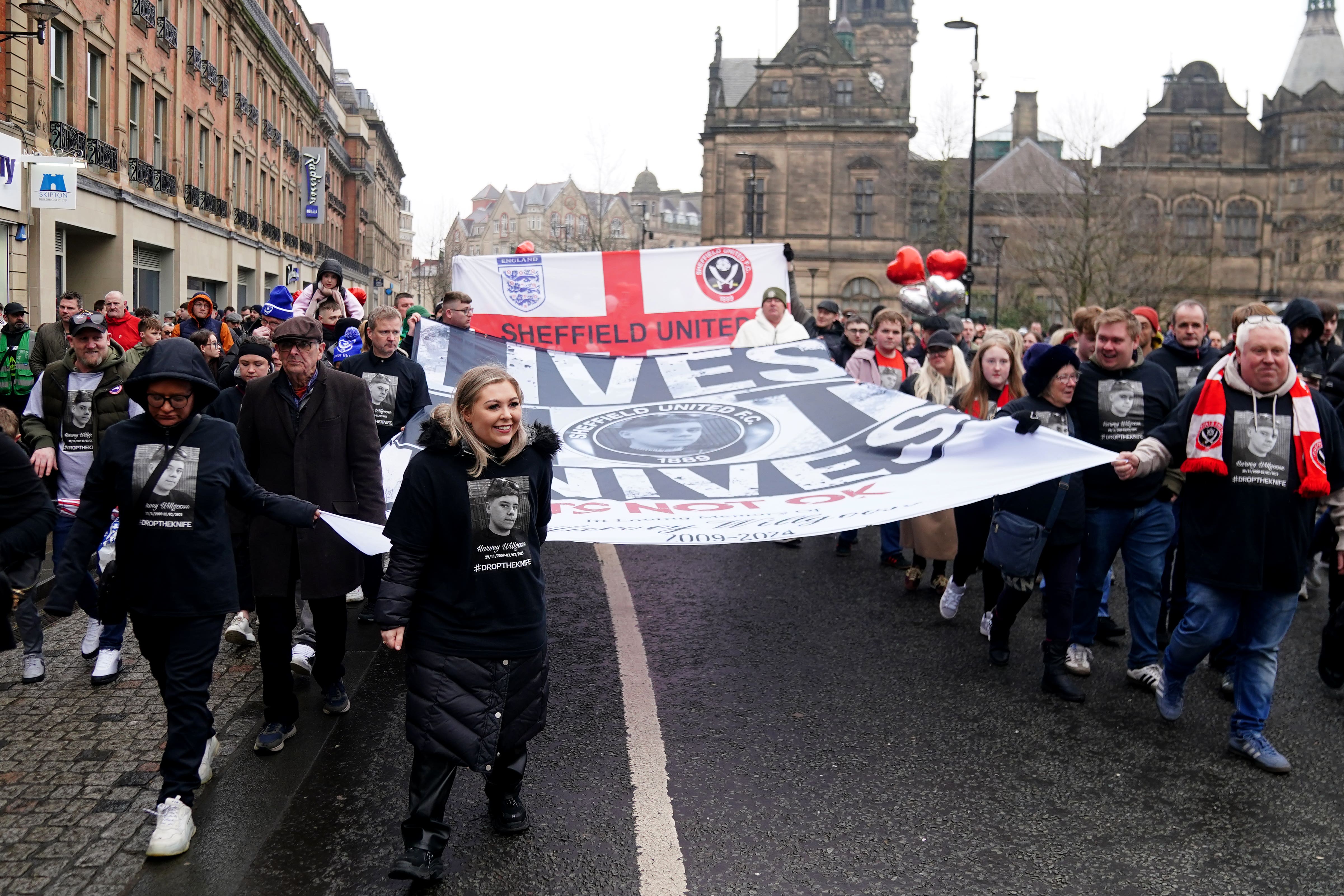 Harvey Willgoose’s parents Caroline Willgoose (left) and Mark (right) holder a banner as they march to Bramall Lane in memory of their son, ahead of the Sheffield United vs Portsmouth match