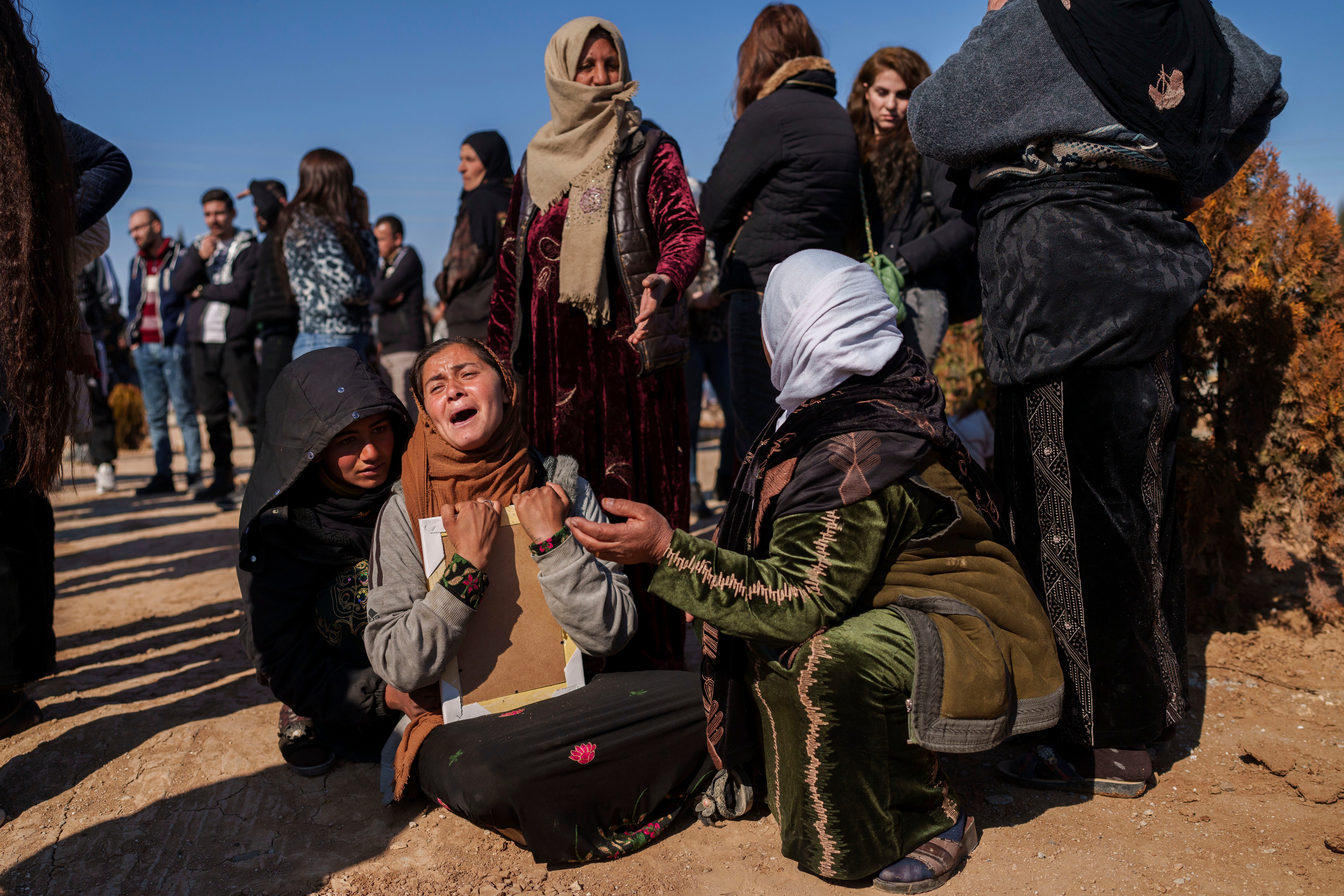 Women comfort a relative of Ibrahim al-Hamad, who was killed by a Turkish-backed militia