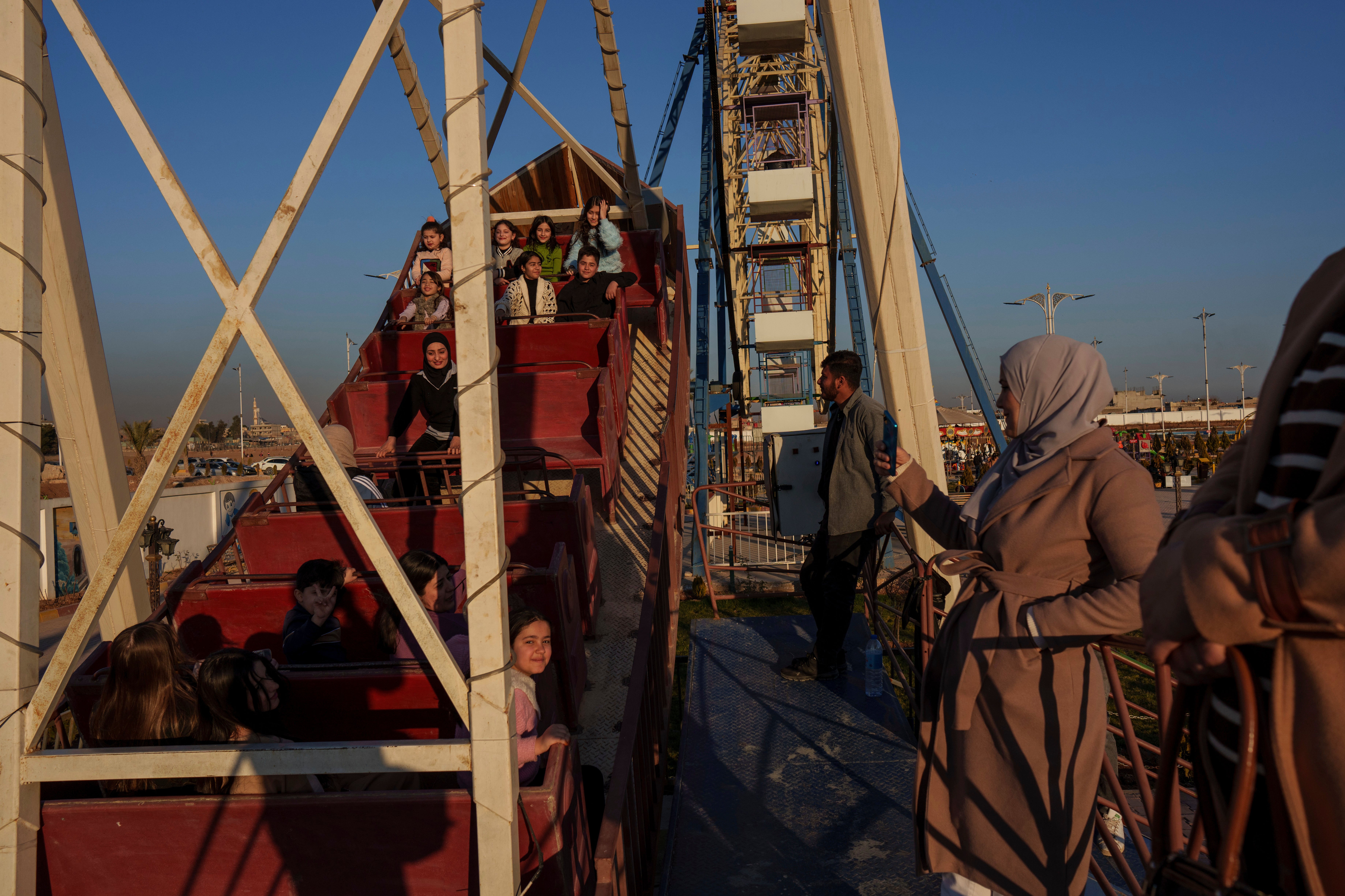Families enjoy an amusement park in the northeastern Syrian city of Qamishli